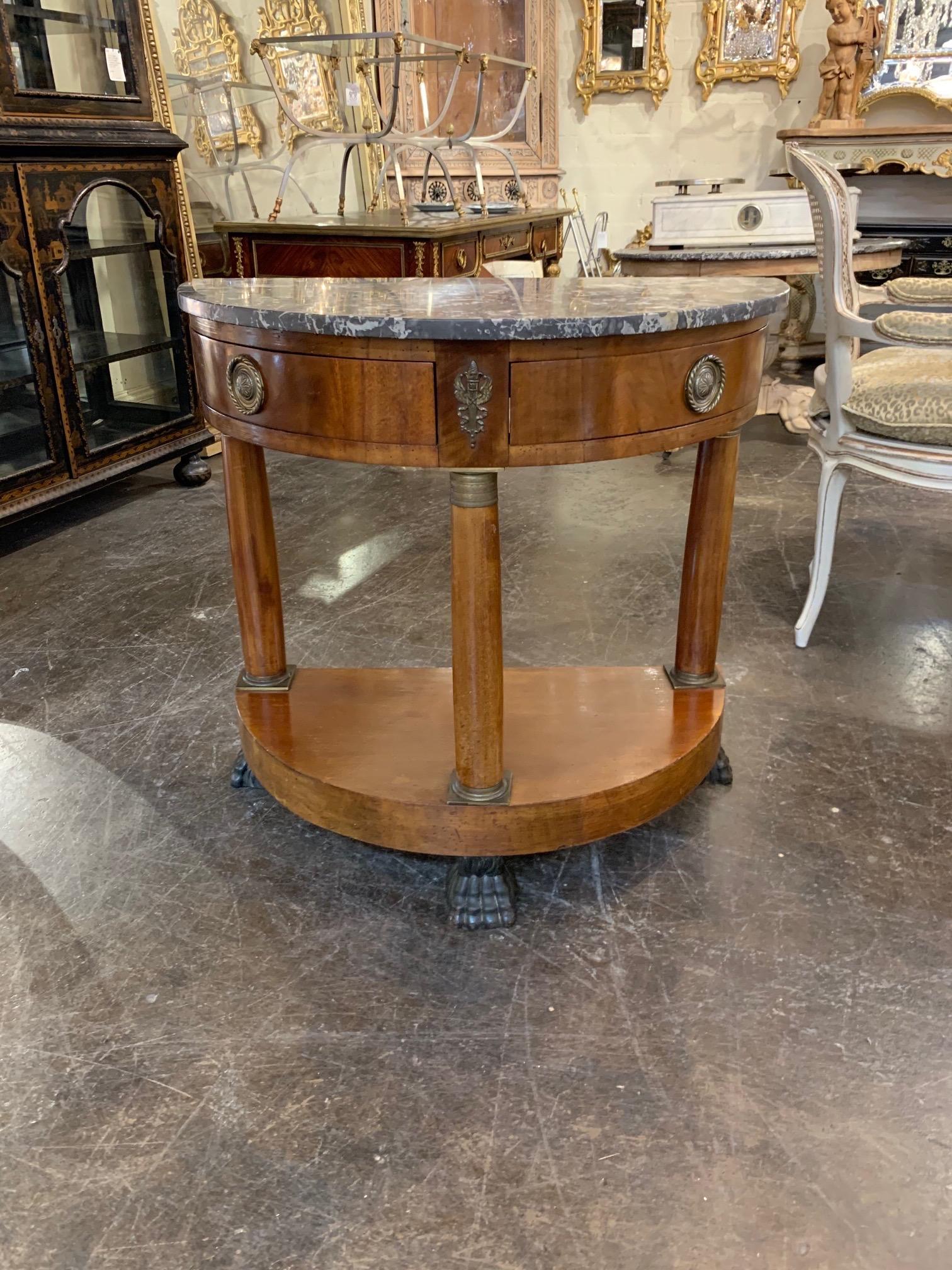 Very fine 19th century French Empire mahogany demilune side table with grey marble top. Nice details including brass hardware and claw feet. Beautiful finish on this piece as well!