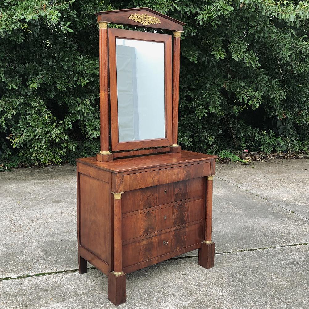 19th century French Empire mahogany dresser with mirror was crafted during the 2nd Empire under the reign of Napoleon III, and features a revival of the style that was heavily influenced by Classical Greek and Roman architecture with Egyptian