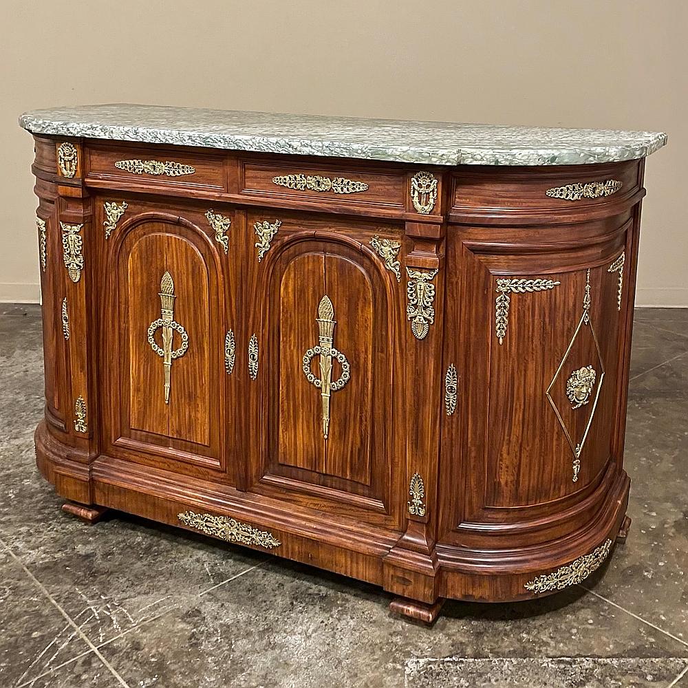 19th Century French Empire mahogany marble top buffet is a marvel of the cabinetmaker's art! First, exotic imported mahogany was employed to create a rich, beautiful background using tailored architectural styling. Then, intricate castings in solid