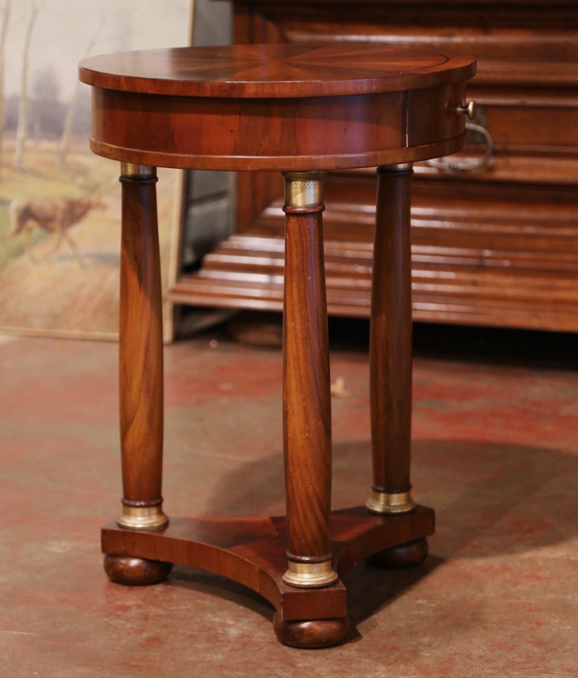 Crafted in France circa 1880, the elegant antique gueridon stands on three turned legs with bottom shaped stretcher and ending with bun feet. Each columnar support is dressed with patinated gilt brass rings at the base and at the neck. Over a