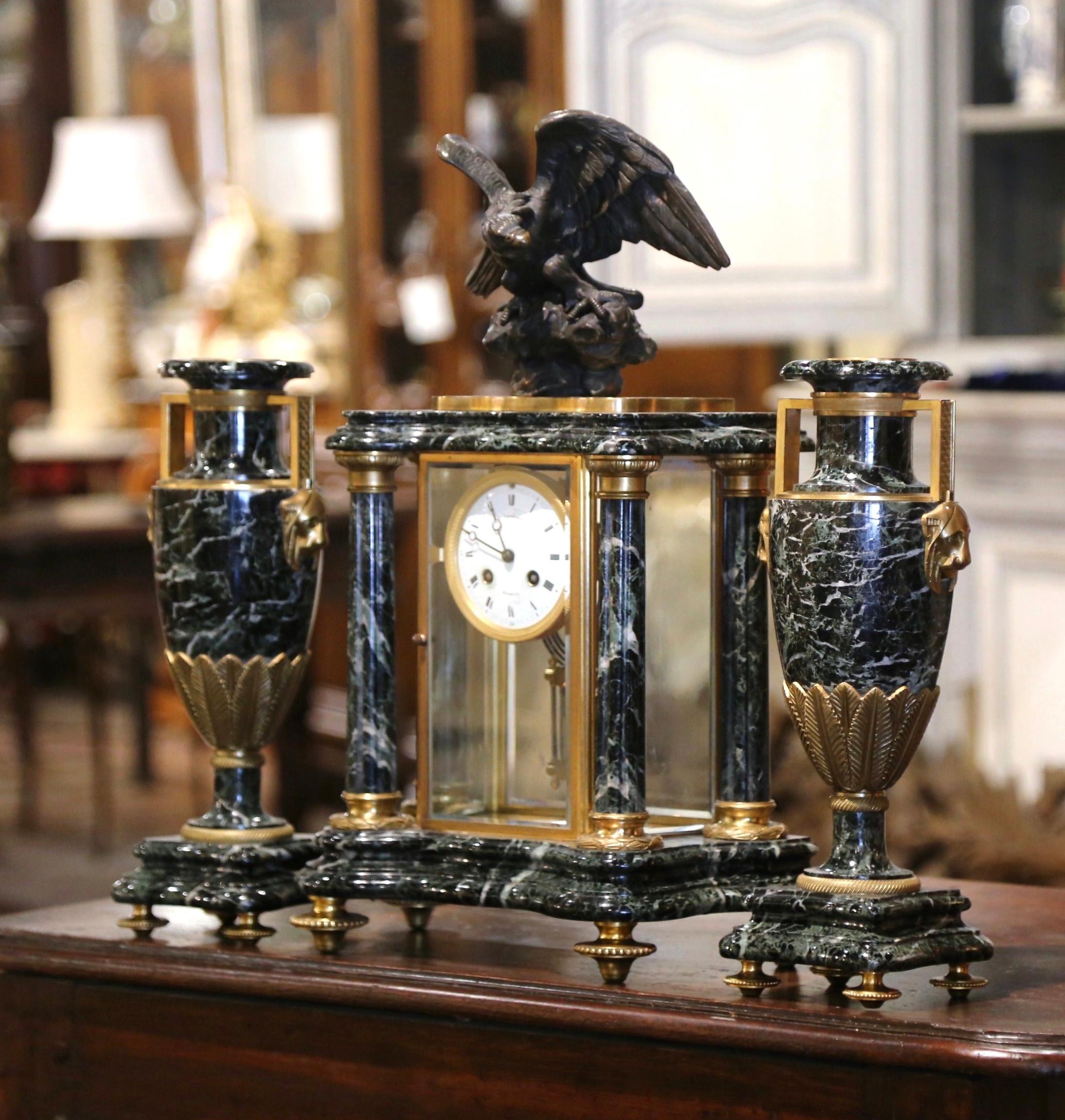 Decorate your mantel with this large Empire clock garniture set. Crafted in Paris, circa 1860, this French antique clock set is a stunning example of 19th-century craftsmanship, featuring a magnificent combination of green marble and gilt bronze.