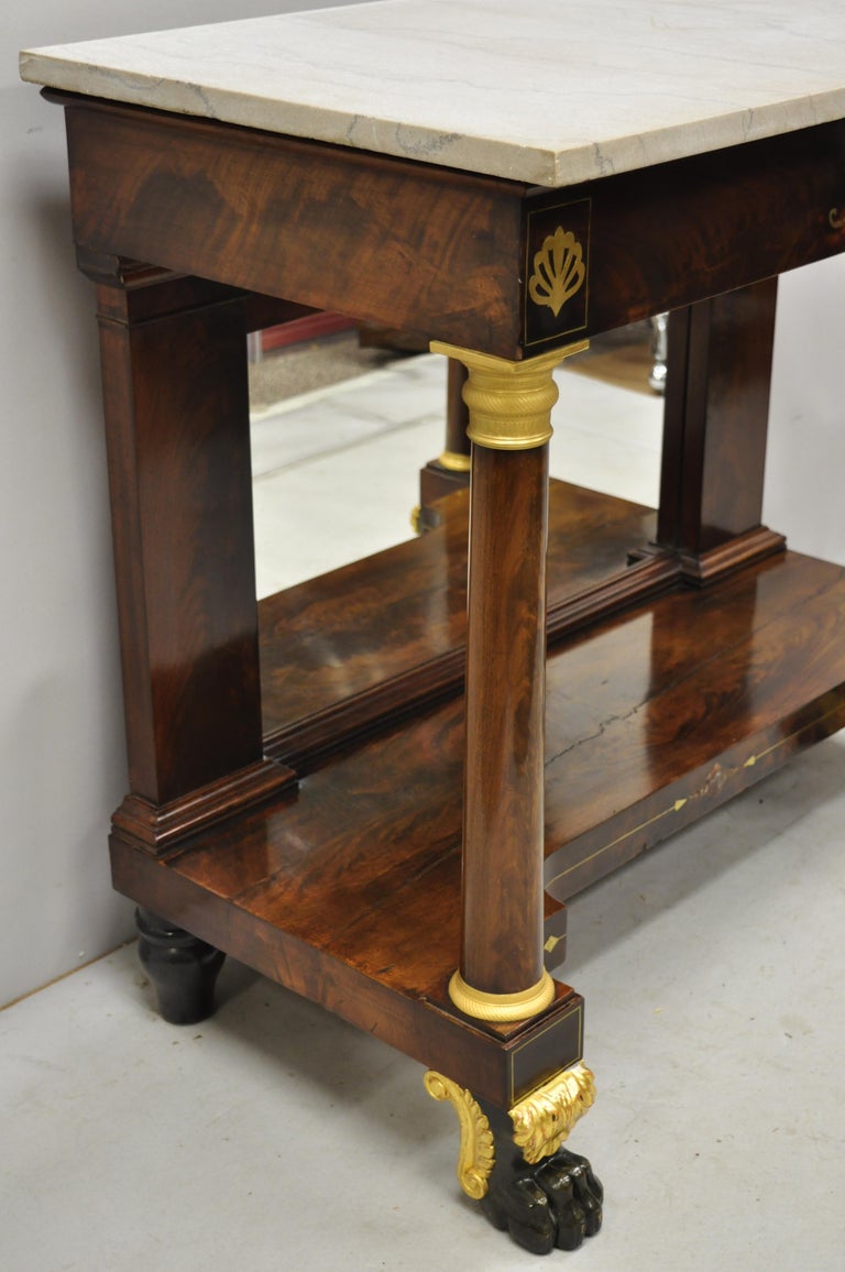 19th century French Empire marble-top bronze ormolu paw feet console hall table. Item features finely cast bronze Ormolu, paw feet, gold gilt accents, bronze inlay, marble top, mirror back, stunning crotch mahogany veneer, very nice antique item,