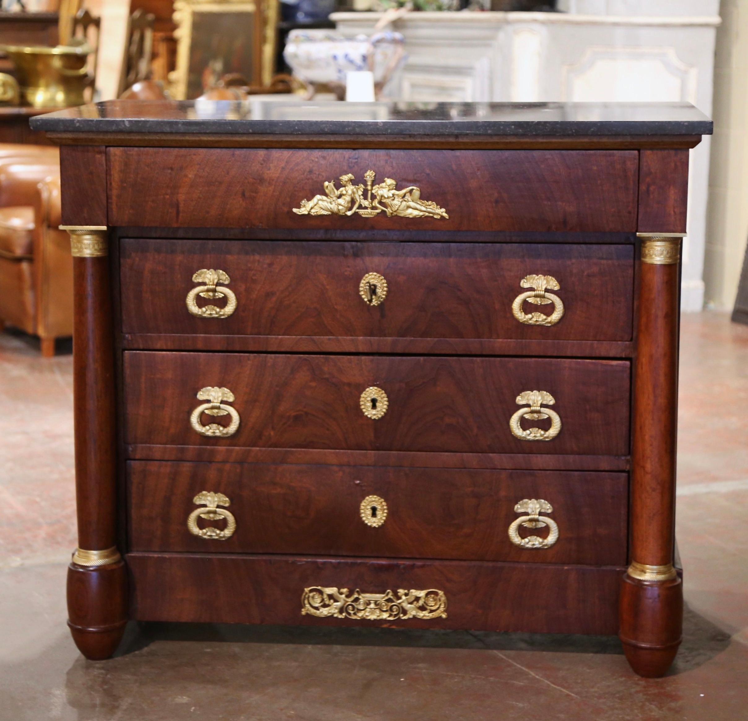 This elegant antique chest of drawers was crafted in France, circa 1860. The traditional commode sits on round columnar feet over a straight bottom plinth decorated with a brass mount, and is embellished on both sides by carved round columns with