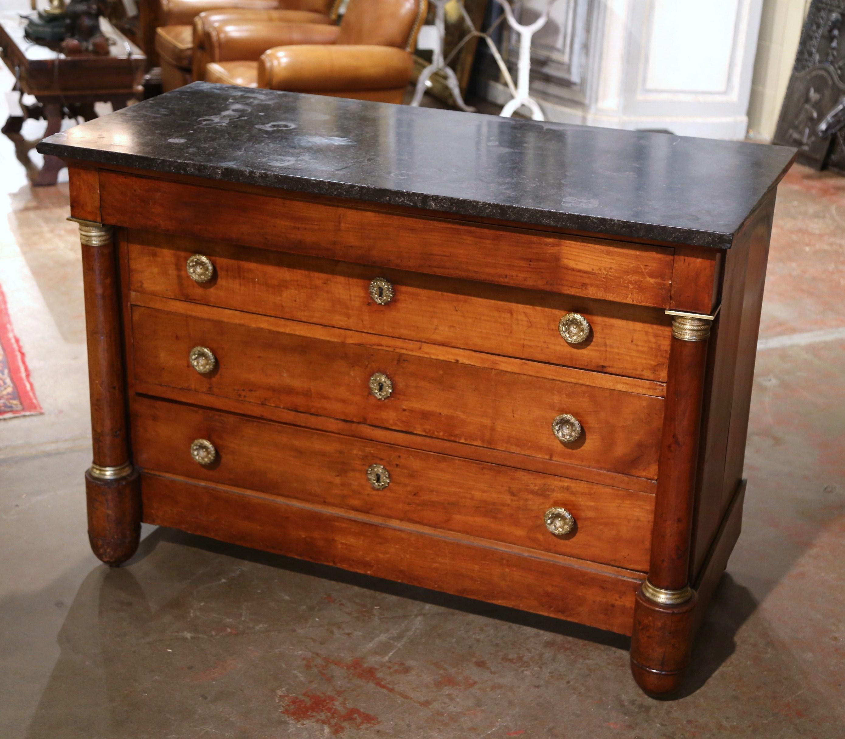 This elegant fruitwood chest of drawers was crafted in France, circa 1860. The traditional commode sits on round columnar feet over a straight bottom plinth, and is embellished on both sides by carved round columns with decorative bronze rings at