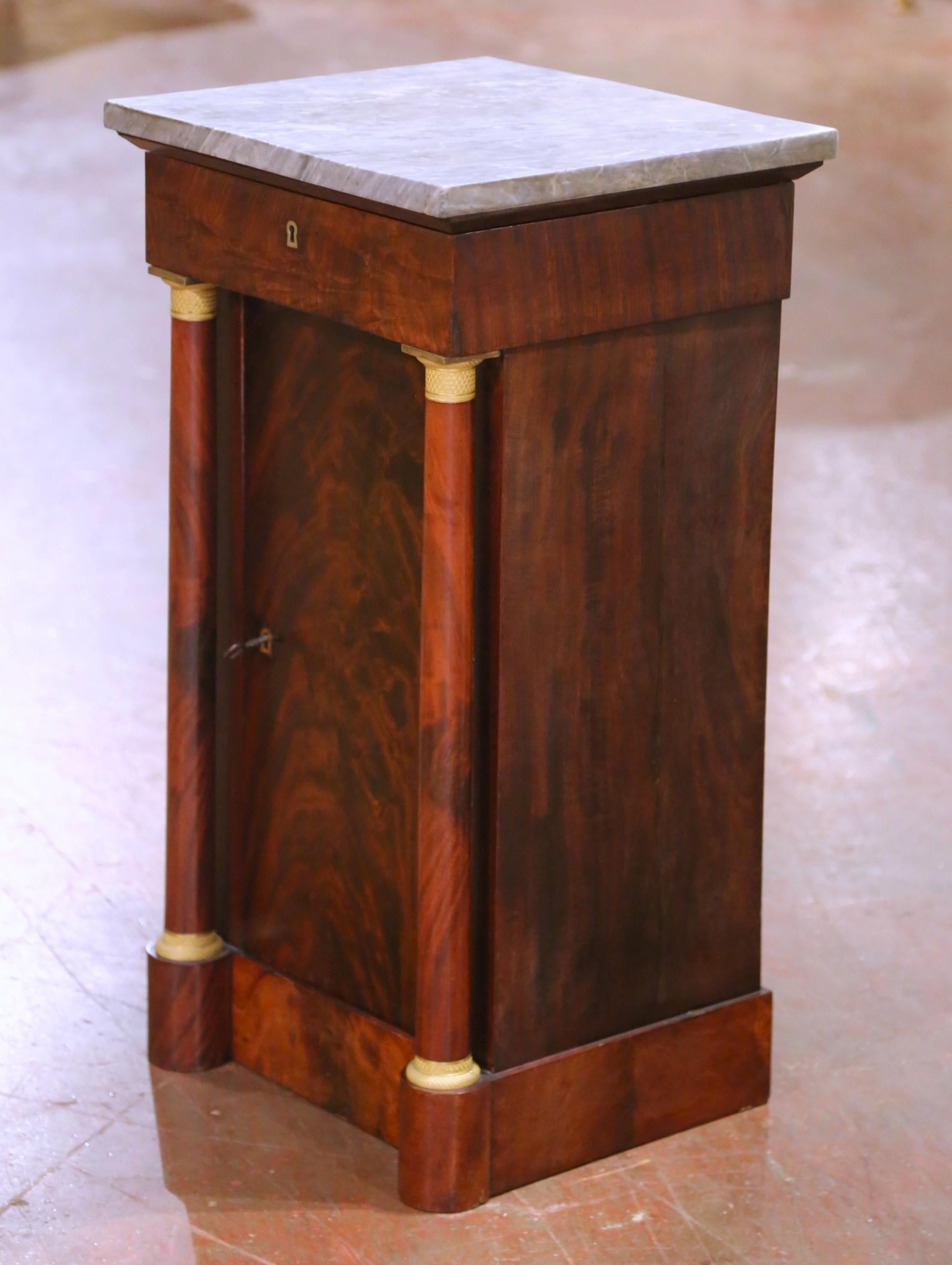 Dieser elegante Obstholzschrank, der um 1860 in Frankreich gefertigt wurde, ist ein Beispiel für den klassischen Empire-Stil. Der antike Waschtisch ist auf beiden Seiten mit fein geschnitzten Rundsäulen verziert, die am Hals und am Sockel mit