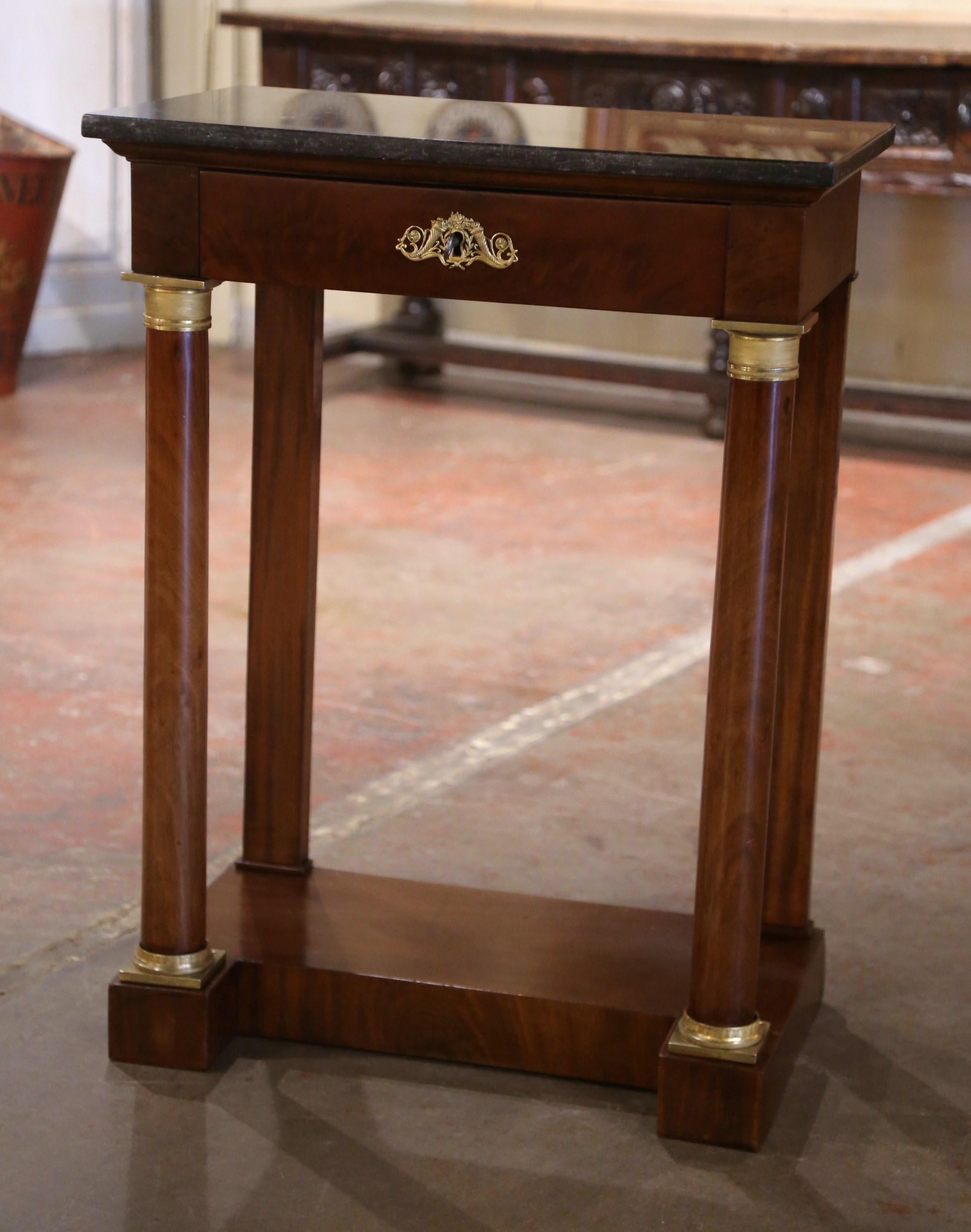 Fabriqué en France vers 1870 et construit en bois d'acajou, l'élégant cabinet ancien repose sur des supports à colonnes arrondies à l'avant, agrémentés d'anneaux décoratifs montés en bronze à l'épaule et au fond, et se terminant sur une base à