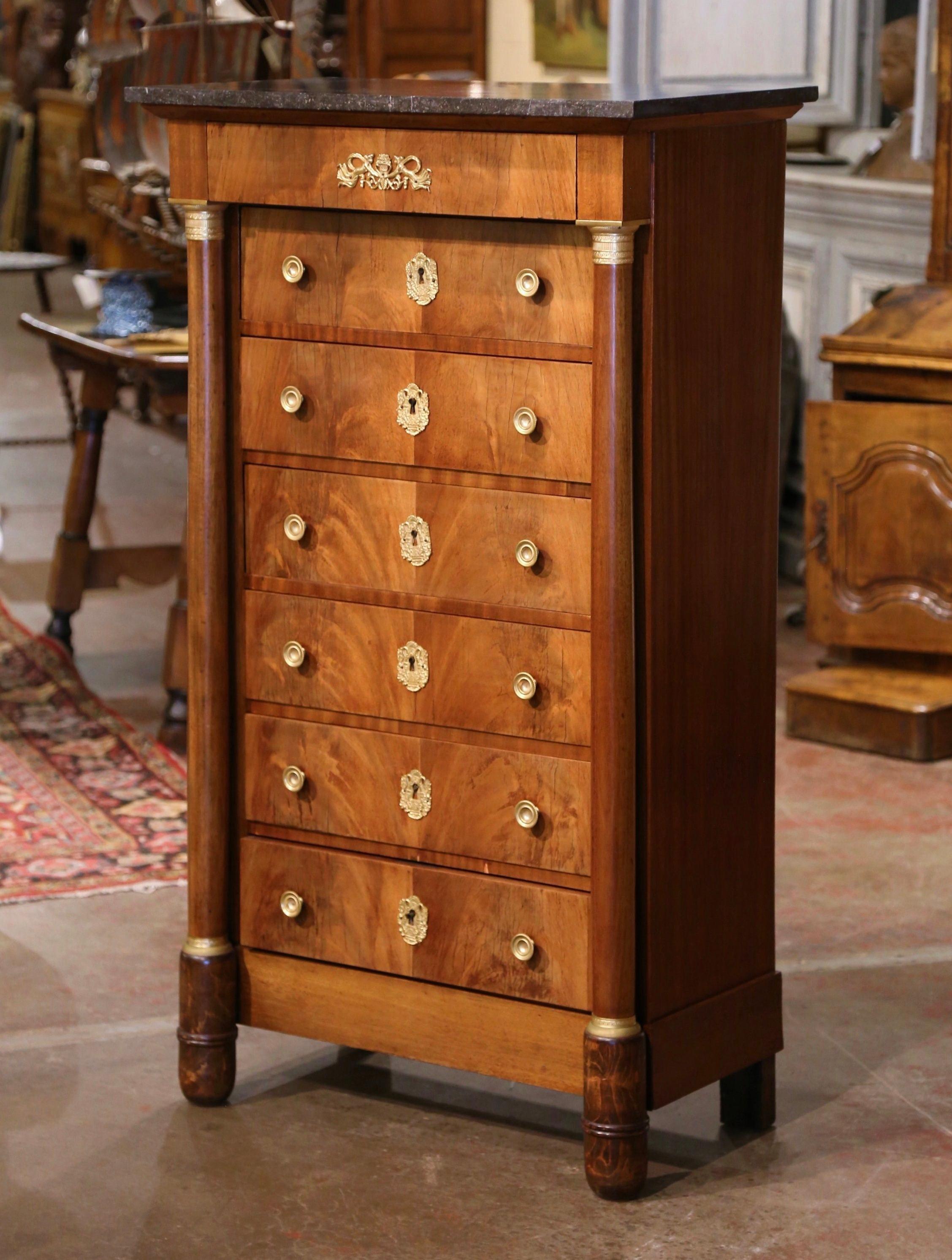 Decorate a bedroom or dressing room with this antique fruitwood Semainier chest of drawers. Crafted in France circa 1880, the tall and narrow chest stands on rounded front cup feet over a straight plinth base; the cabinet features a projecting