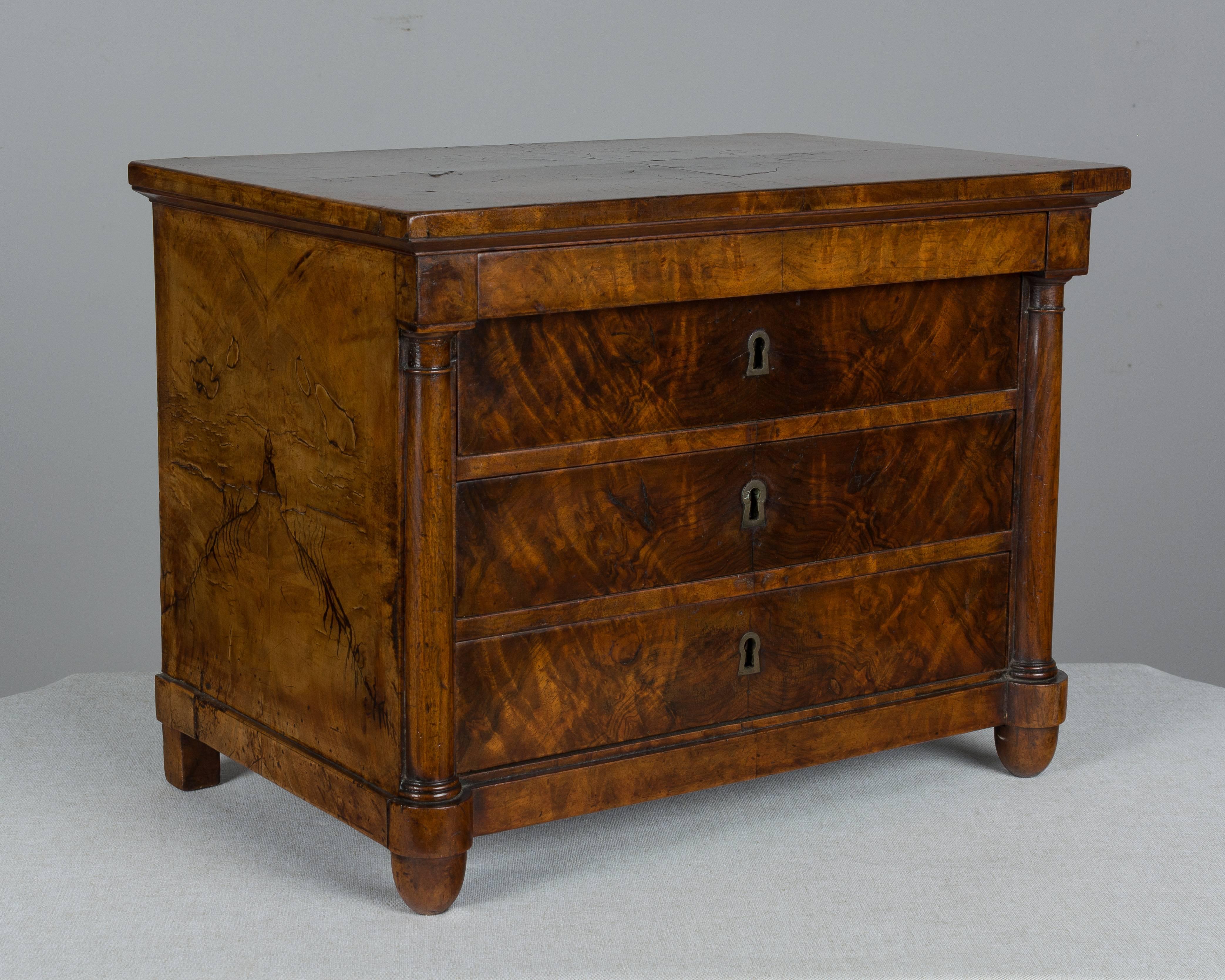A fine early 19th century French Empire miniature sample commode with four dovetailed drawers. Made of burl of walnut veneer with oak and pine as secondary woods. Working locks with one key. French polish finish. Excellent quality. Perfect for