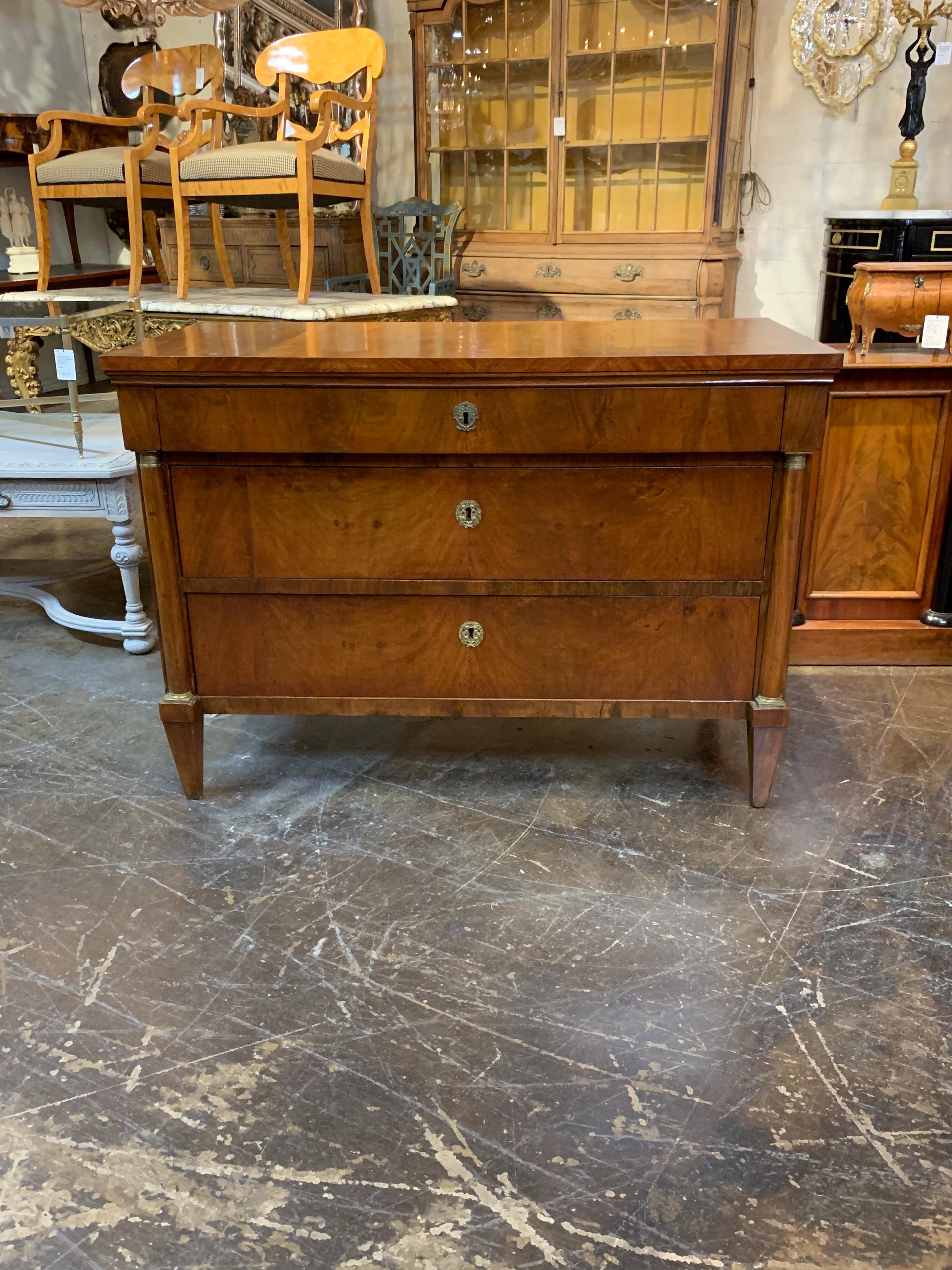 Handsome 19th century French Empire neoclassical chest of drawers with brass trim. Absolutely gorgeous finish on this piece! A classic style that would blend well with multiple types of decor. Stunning!