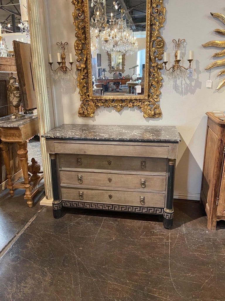 Beautiful 19th century French Empire painted commode with decorative Greek Key pattern. The piece also has a gorgeous black marble top and four drawers for storage. Notice the lion drawer pulls as well. A very unique and lovely chest!!