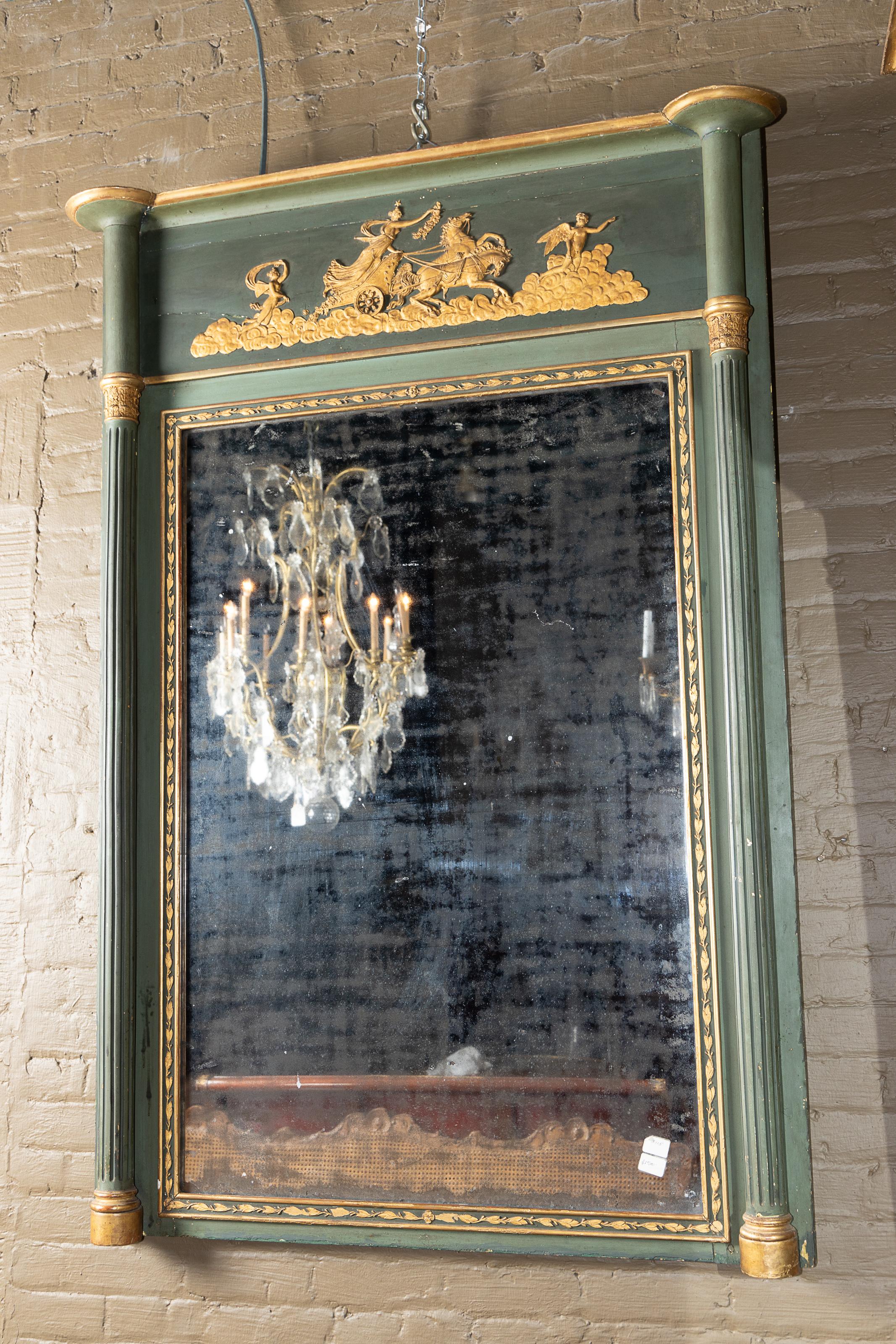 Questo bellissimo specchio trumeau dell'Impero francese è dipinto in un bel verde con una bella patina e risale al XIX secolo. Il pezzo sfoggia il vetro originale del 1800 ed è ornato da personaggi allegorici dorati nella parte superiore. Diana la