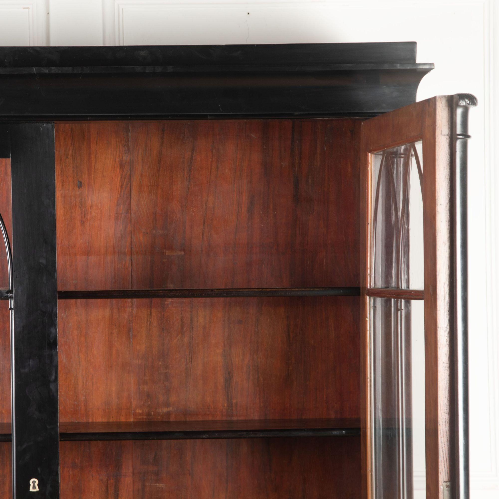 Great quality early 19th century ebonised French Empire period bookcase.
Having a moulded cornice above a pair of shaped glazed doors with original old glass and flanked by pilasters terminating in classic reeded bun feet.
circa 1830.