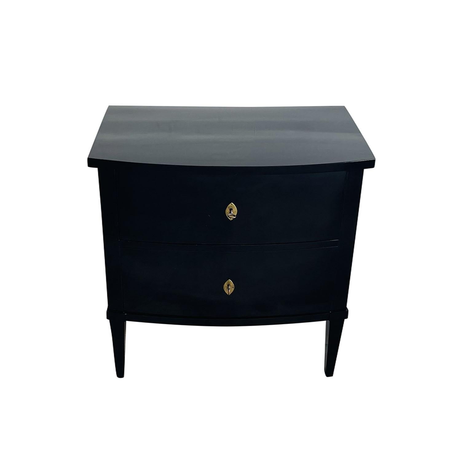 Une ancienne table de nuit Empire française du début du 19ème siècle, en ébène poli à la gomme-laque, en bon état. La commode parisienne noire est composée de deux tiroirs, particularisés par leur quincaillerie et leurs clés en laiton d'origine. Le