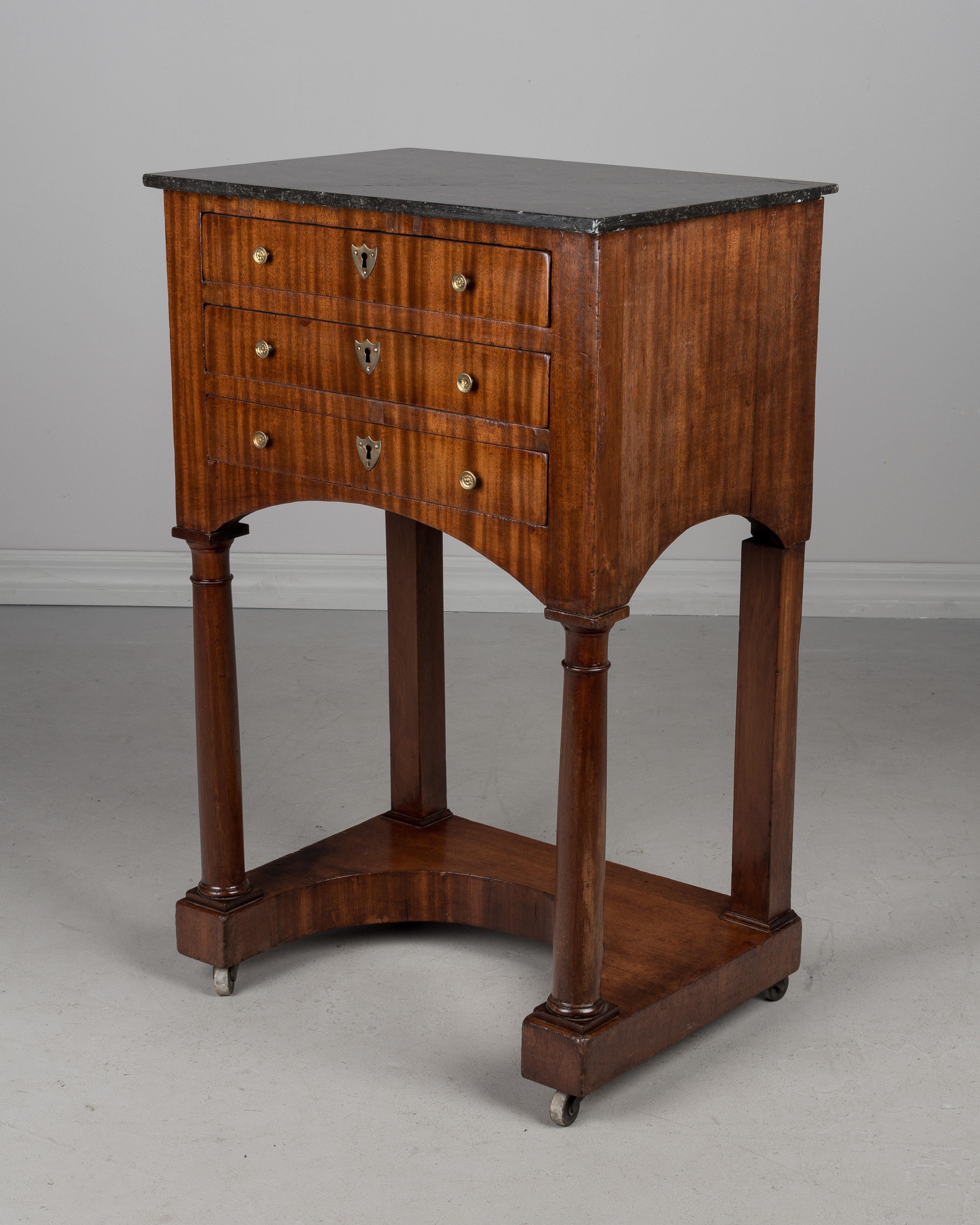 A fine 19th century French Empire marble-top side table made of mahogany veneer with solid oak as a secondary wood. Three dovetailed drawers with original bronze hardware. No key. Original castors. French polish finish. Marble-top was cracked and