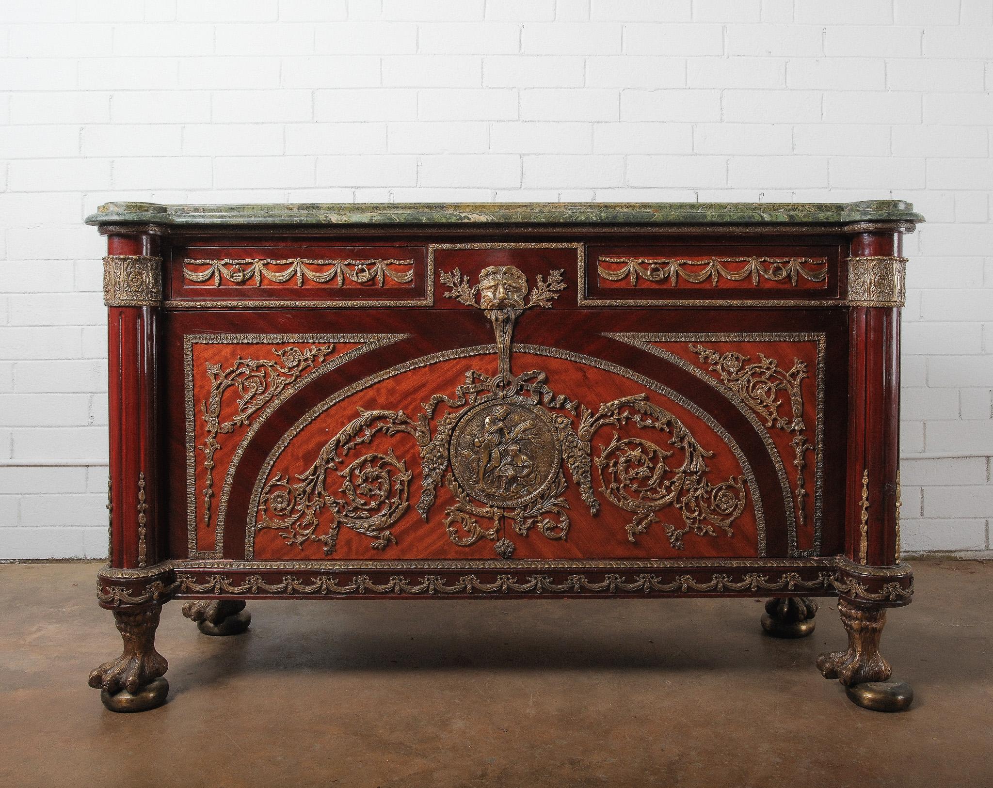 Un'impressionante credenza o credenza in mogano in stile Impero francese del XIX secolo, riccamente ornata da decorazioni in bronzo dorato (ormolu) e coronata da un imponente piano in marmo verde. La parte anteriore è splendidamente pannellata e