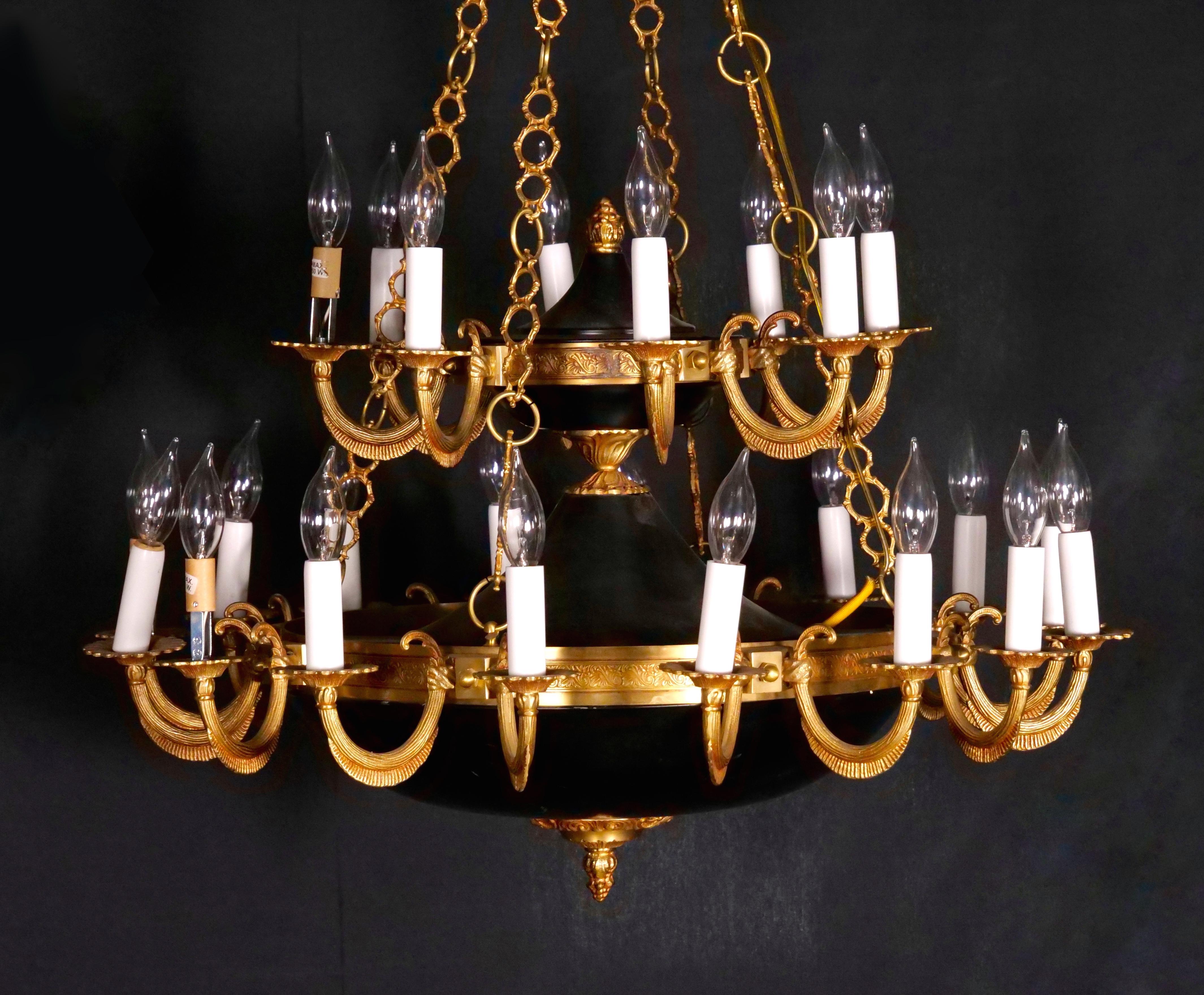 Illuminate your space with grandeur using this extraordinary 19th Century French Empire Style Chandelier. Crafted from two imposing circular charcoal-patinated balusters suspended by four ornate gilt bronze chains, this chandelier is a magnificent