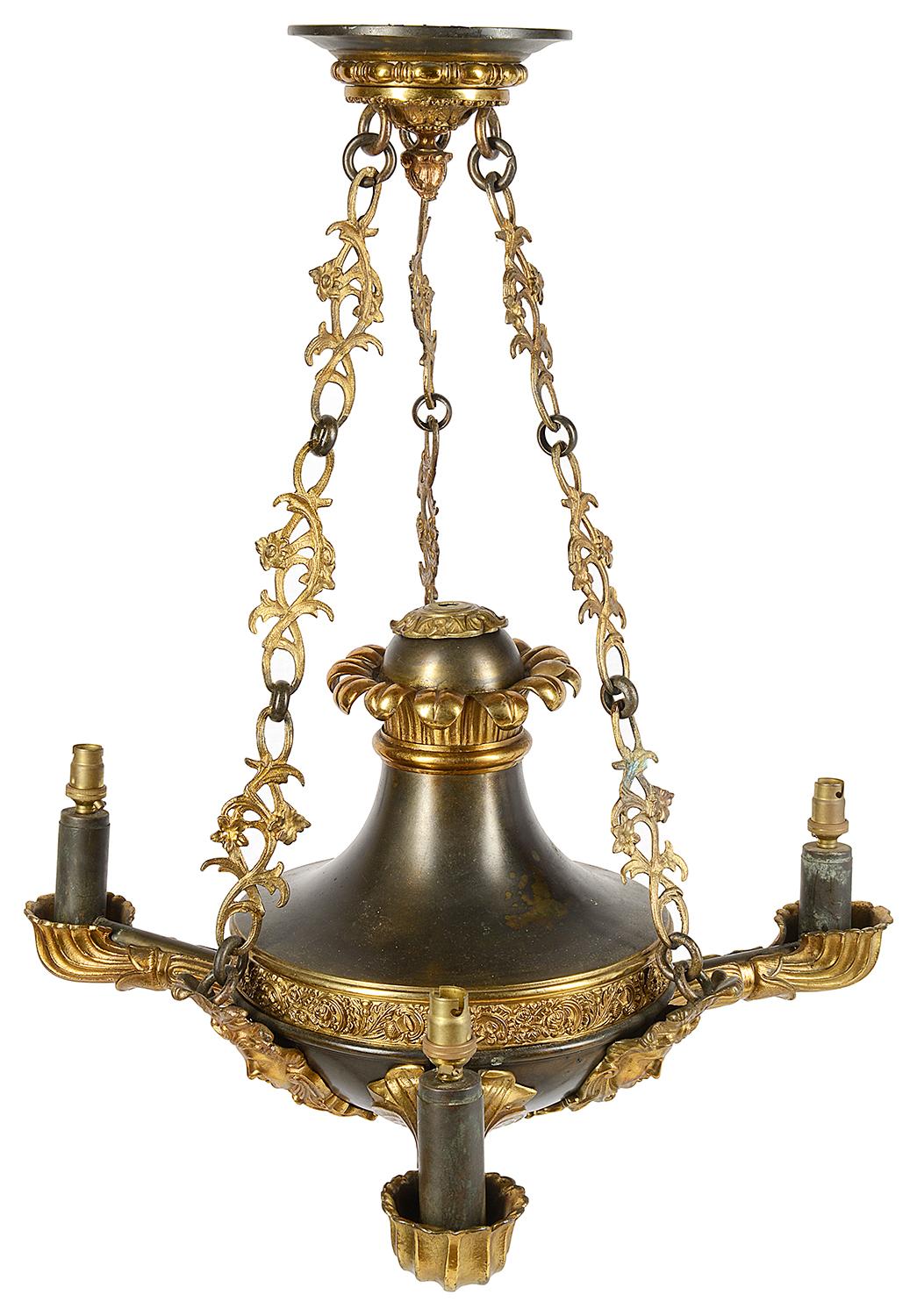 A good quality 19th century bronze and gilded ormolu French Empire influenced chandelier. Having a classical ceiling rose with three foliate linked chains supporting the three branch chandelier, with three masks each with feather plumes.