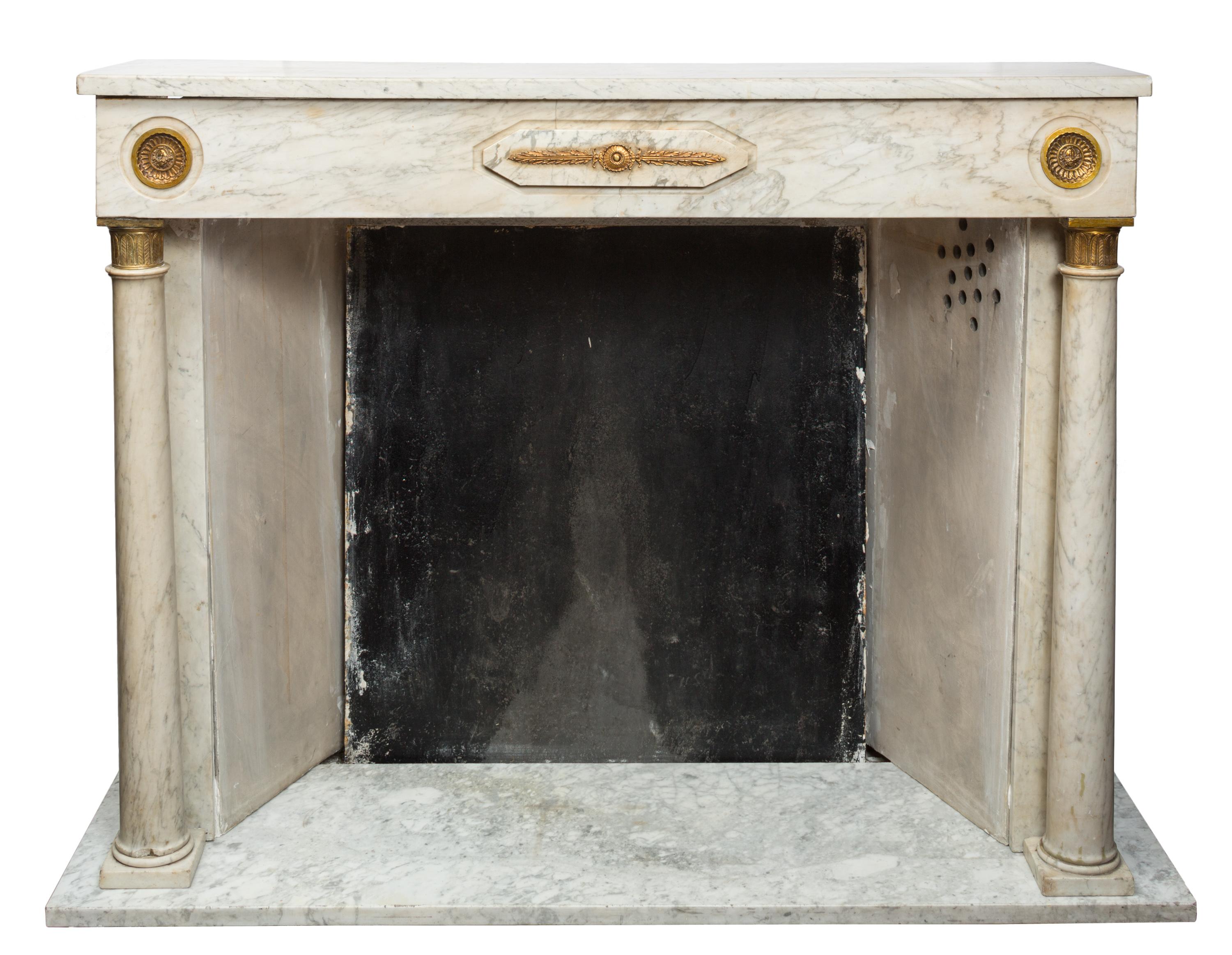 A beautiful and functional 19th century French Empire style fireplace / surround made of richly veined white marble. It is complete with a marble slab hearth, sidewalls, decorative column legs, mantel header and shelf, and a cast iron fire back.