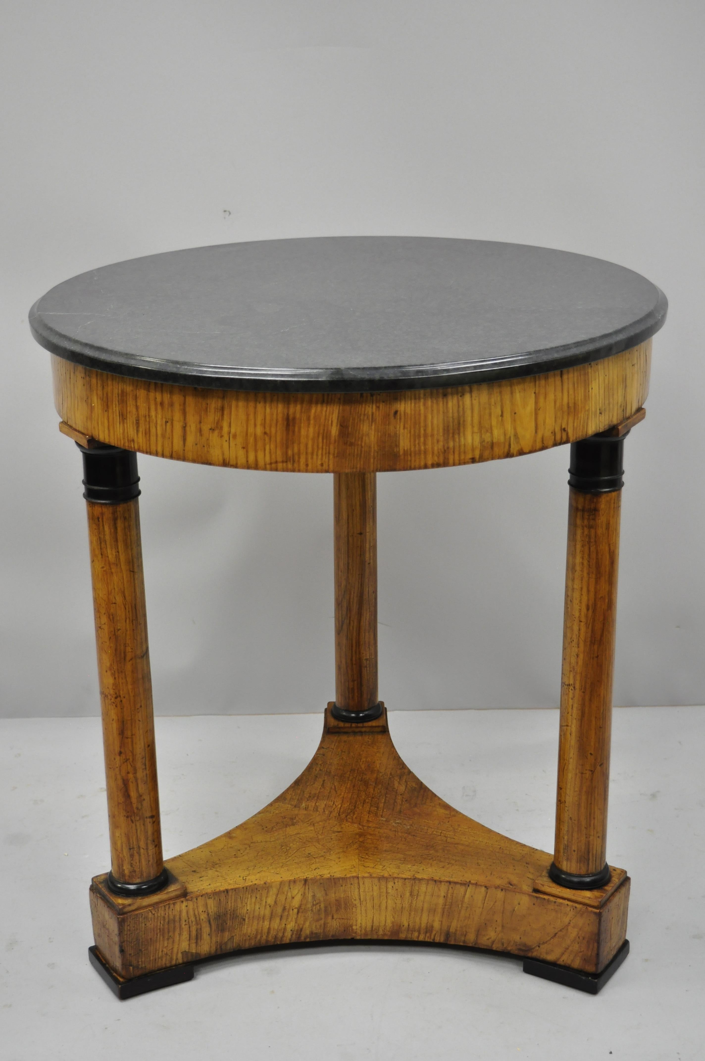 19th century French Empire style round marble-top center table. Item features round marble top, 3 column leg supports, black painted accents, authentic and desirable and distressed finish/patina, circa 19th century. Measurements: 28.5