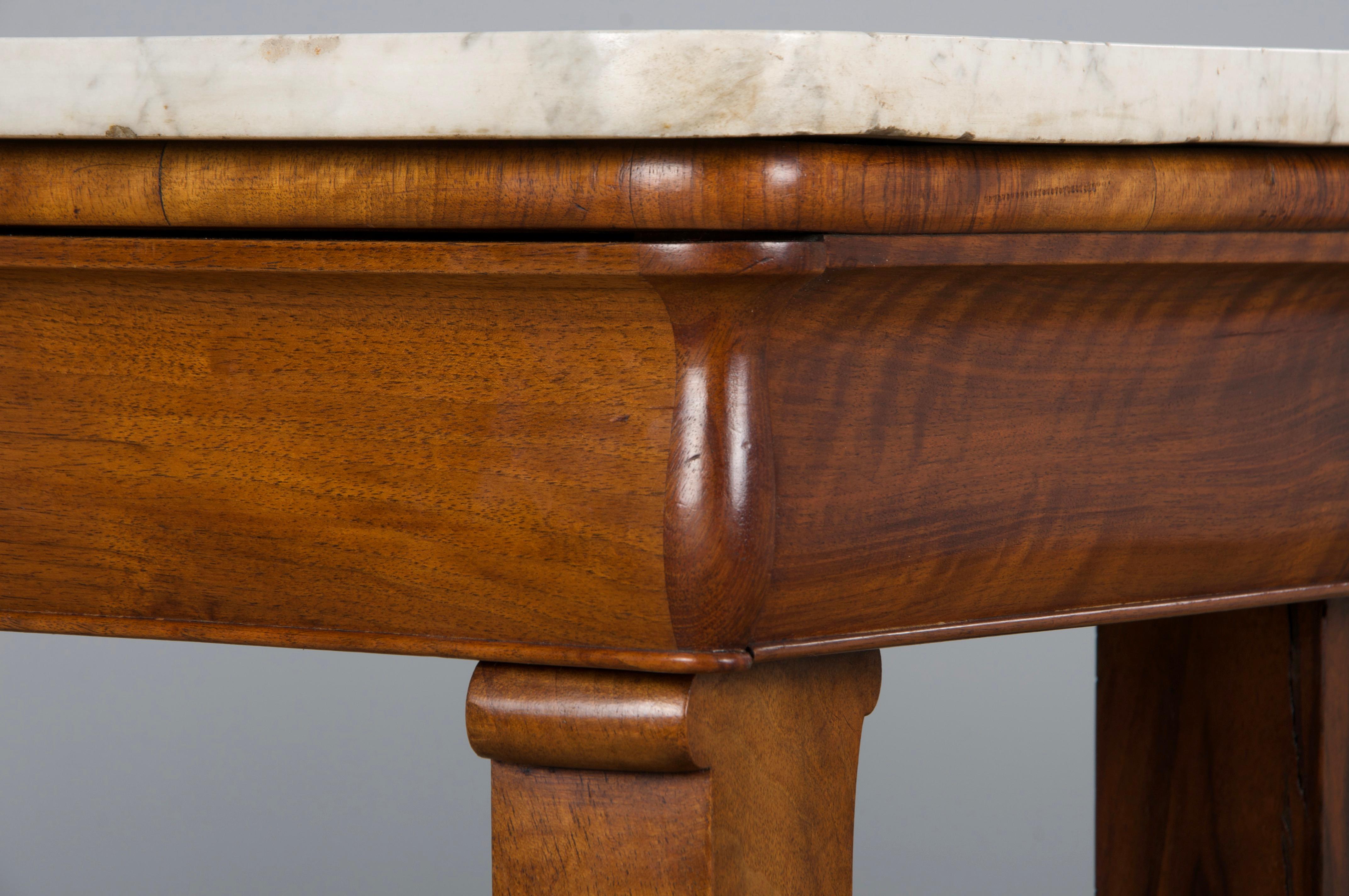 Una squisita consolle francese della metà del XIX secolo in stile Impero, proveniente dalla Provenza, in Francia. Sapientemente realizzato a mano in legno di noce, presenta uno splendido piano in marmo di Carrara di grande spessore, in un morbido