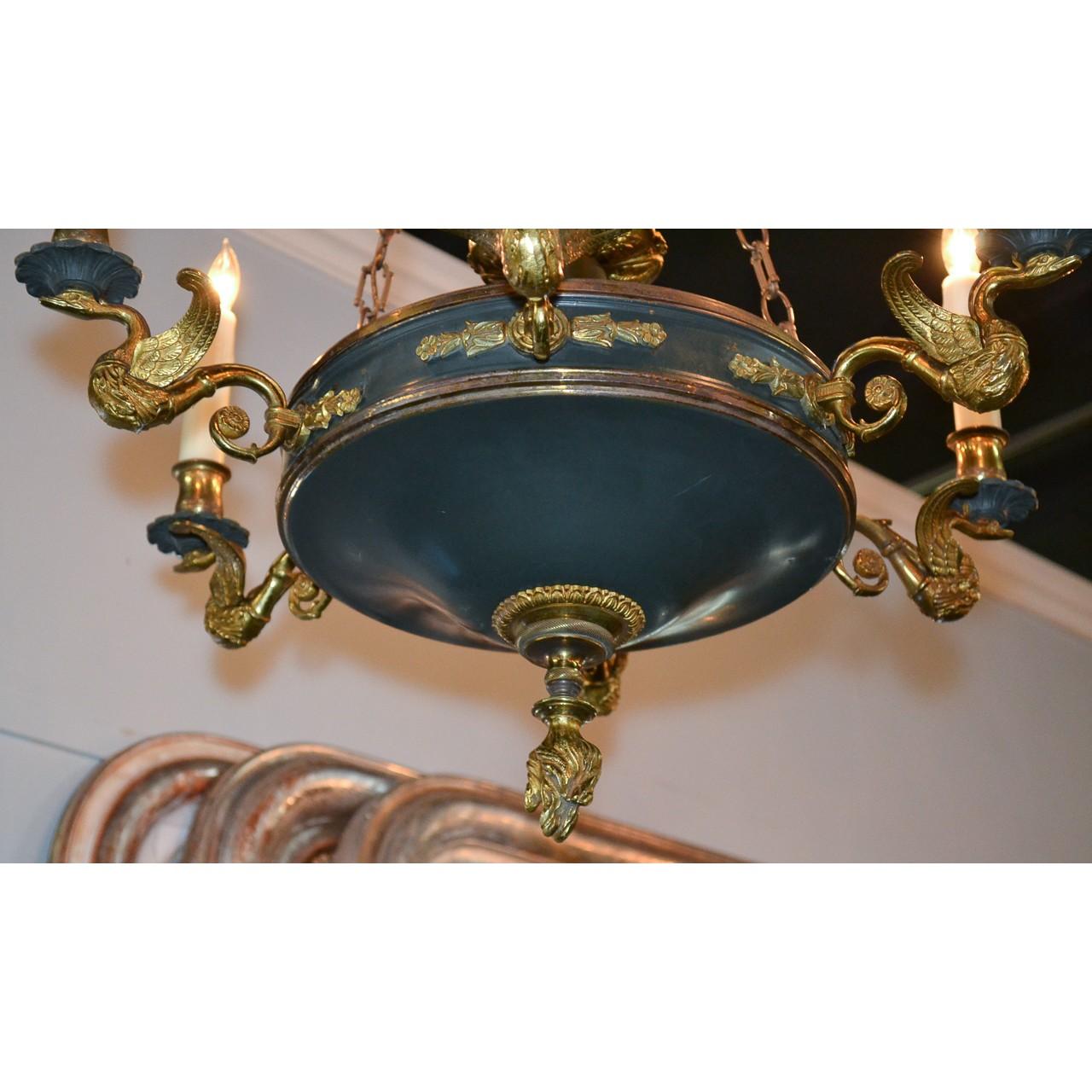Uniquely designed 19th century French Empire style tole and gilt brass chandelier. The crown-shaped top with suspended chains holding a shaped mid-section with decorative acorn finial and mounted with six swan fashioned arms having scalloped bobeche