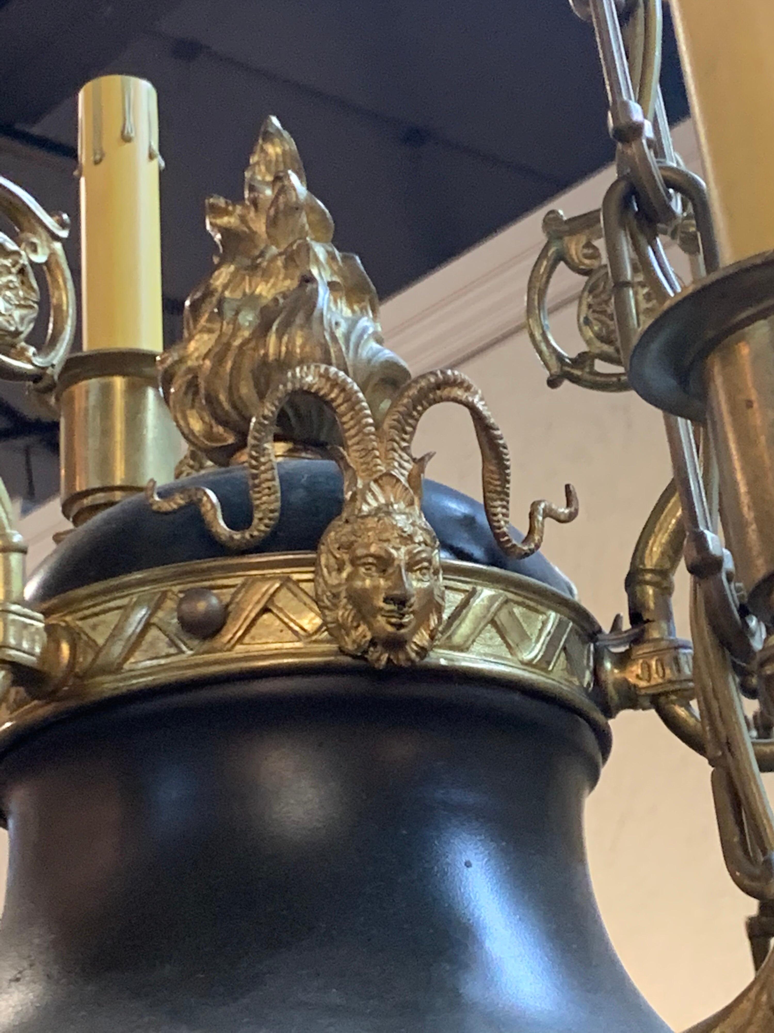 Exquisite 19th century French Empire style tole and bronze 12-light chandelier. Beautiful decorative details on the bronze, including lovely finials and faces on the arms and the top section. Exceptional quality!