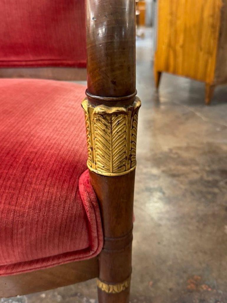 Le fauteuil Empire français en noyer et doré du XIXe siècle est un meuble luxueux.  Ce fauteuil respire l'élégance et la sophistication, ce qui en fait un complément idéal à tout décor. Fabriqué en noyer de haute qualité et orné de touches d'or, il