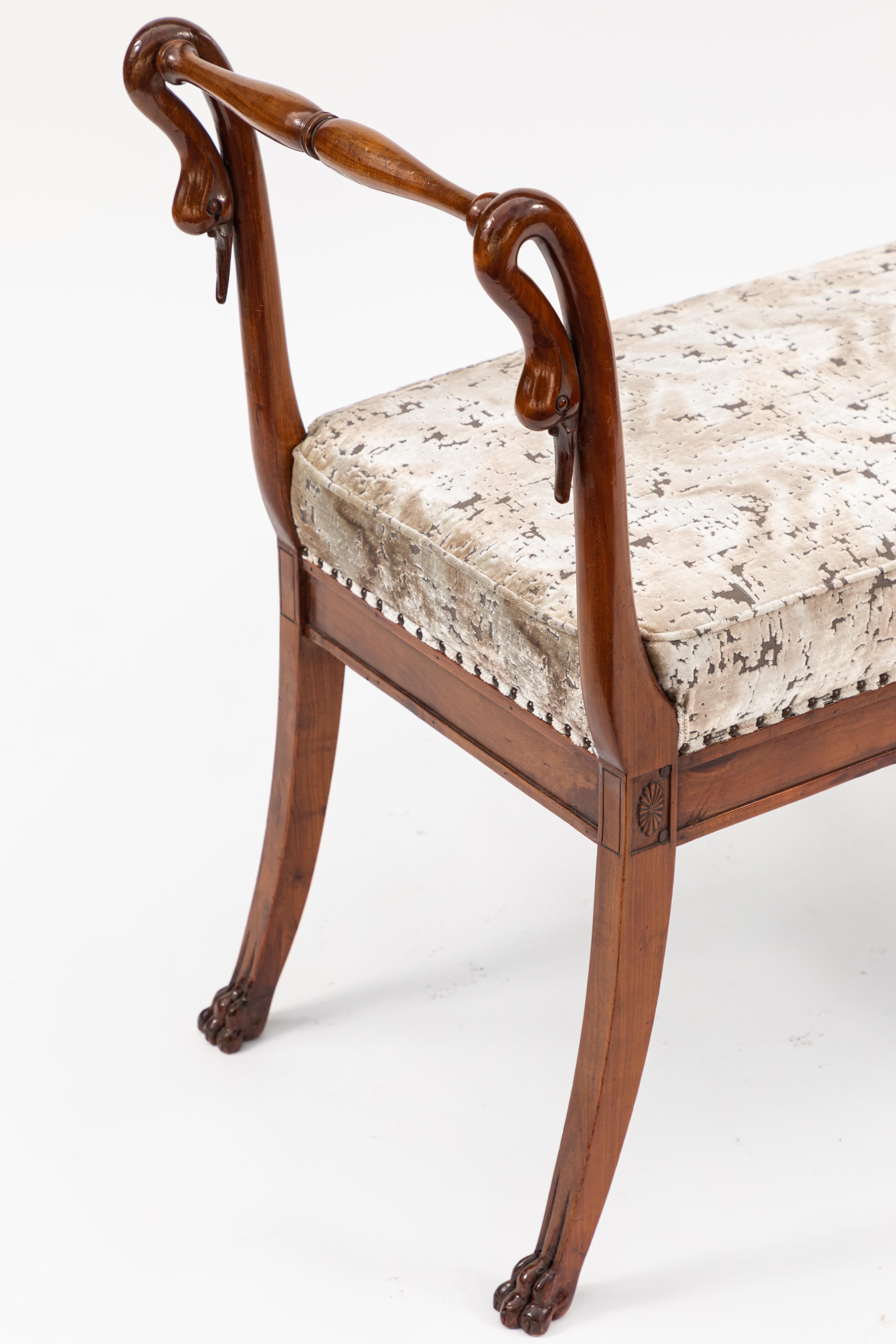 Early 19th century French Empire walnut bench with carved swan motif. Newly upholstered in contemporary velvet.