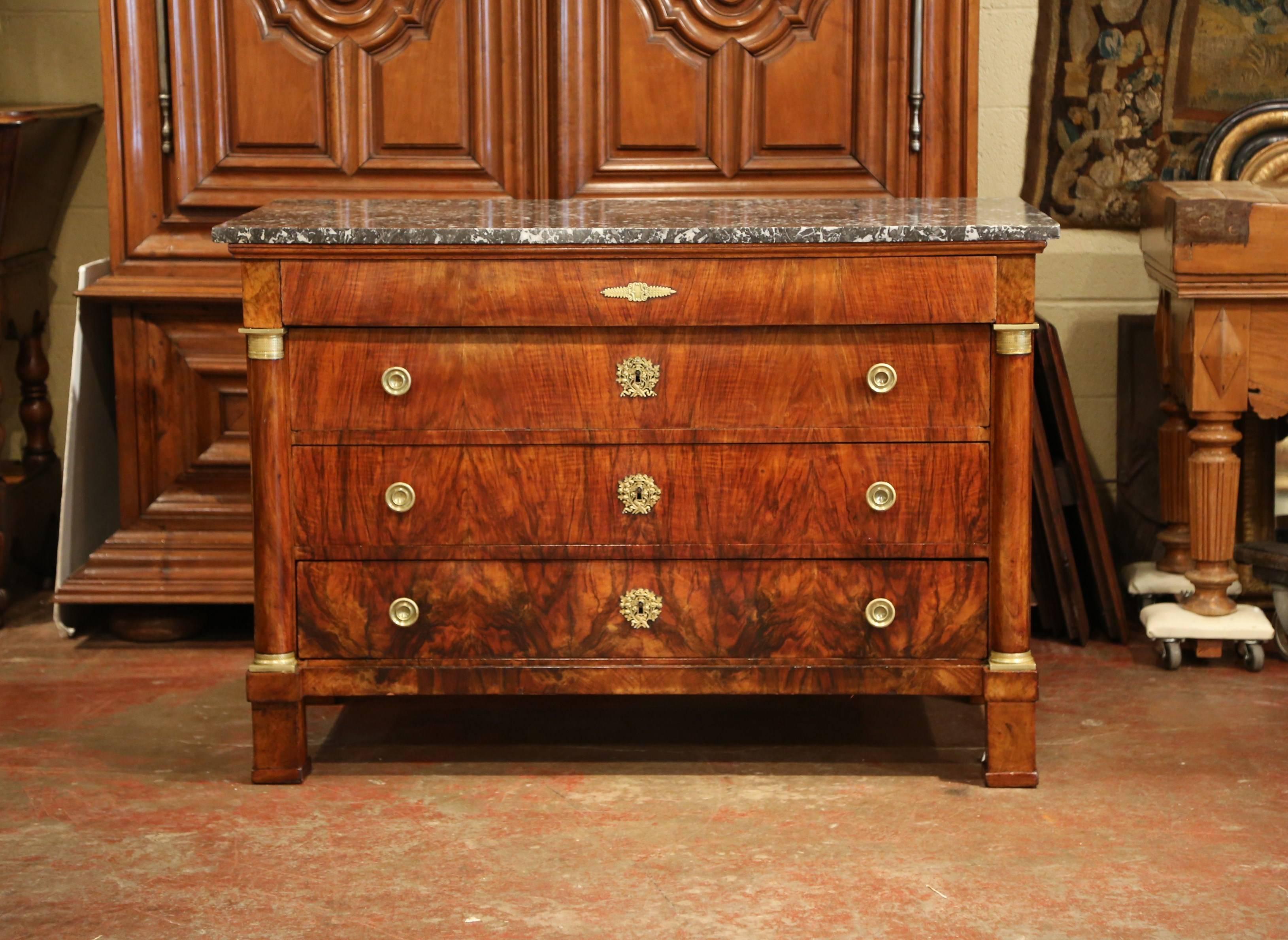 This elegant, antique fruitwood chest of drawers was crafted in France, circa 1830. The traditional commode with veneer marquetry design, features three drawers across the front with original bronze pulls and a fourth additional drawer under the