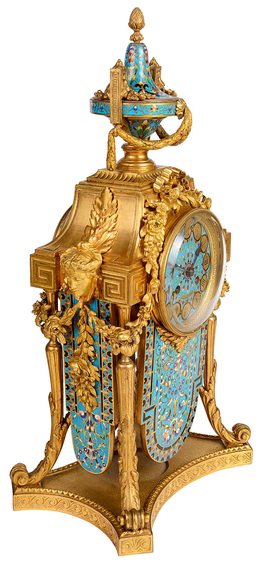 A wonderful quality late 19th century French Louis XVI style gilded ormolu and Champlevé enamel clock garniture, the clock having a two handled turquoise enamel urn with swags above the floral and ribbon decorated eight day duration hour and half