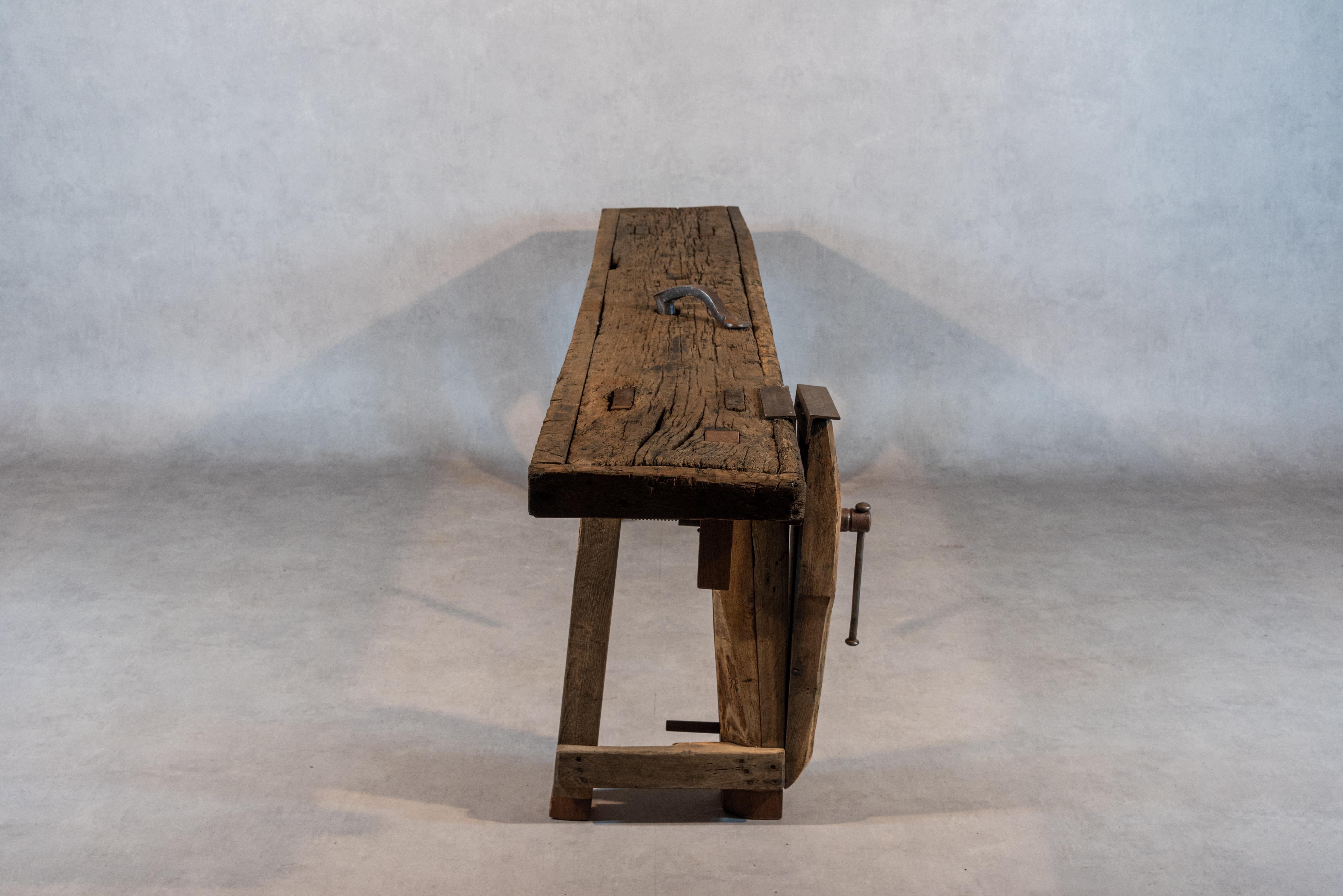 A 19th century French carpenter's workbench or console made of cherry wood. This work table's rugged aspect reflects the rich character and history of the piece and captures the beauty and nobility of carpentry. Although rustic in their allure,