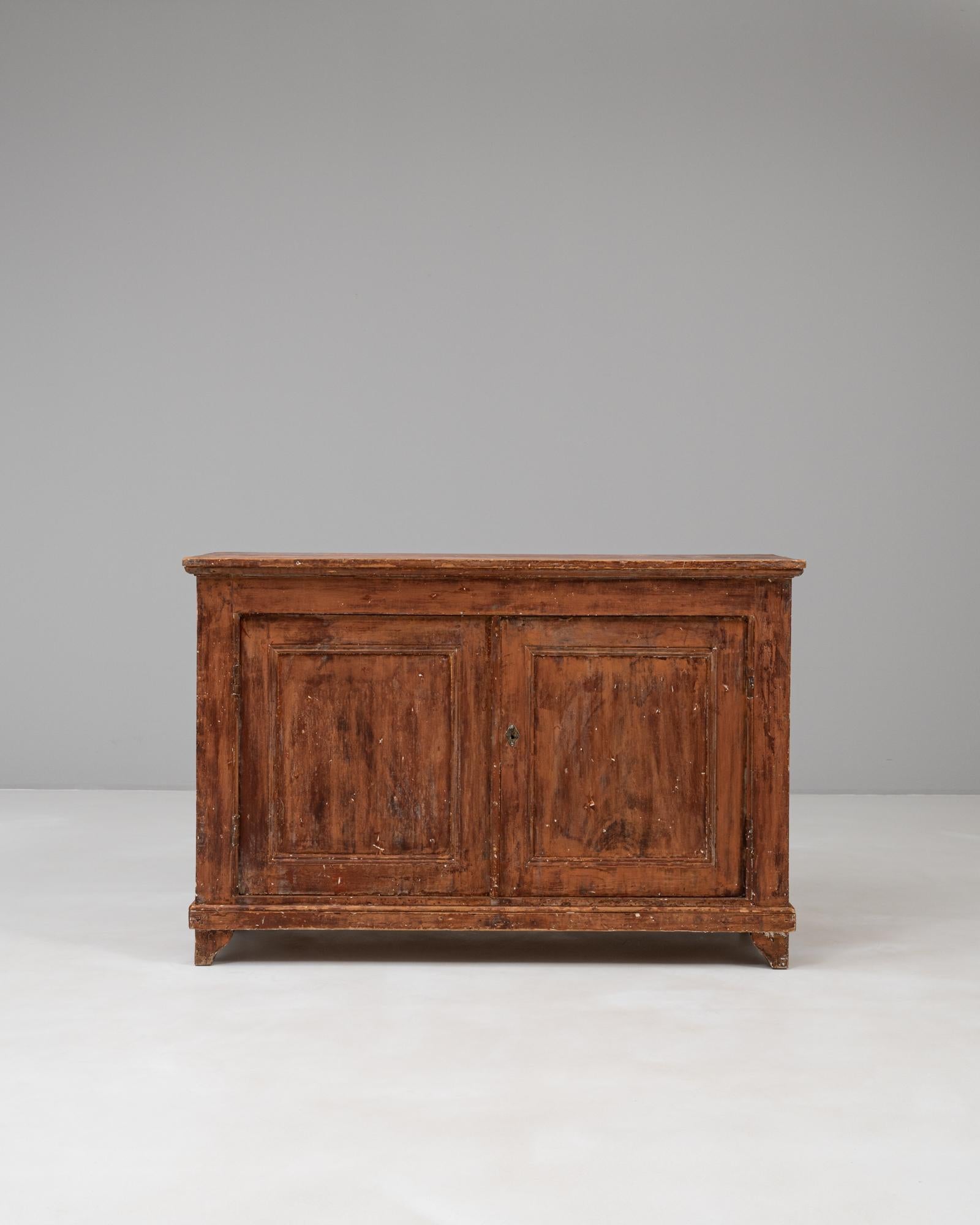 Questo buffet in legno della provincia europea francese del XIX secolo incarna un'eleganza rustica e un design pratico. Realizzato in legno massiccio, presenta due ante a pannelli che si aprono per rivelare un interno spazioso con un unico ripiano,