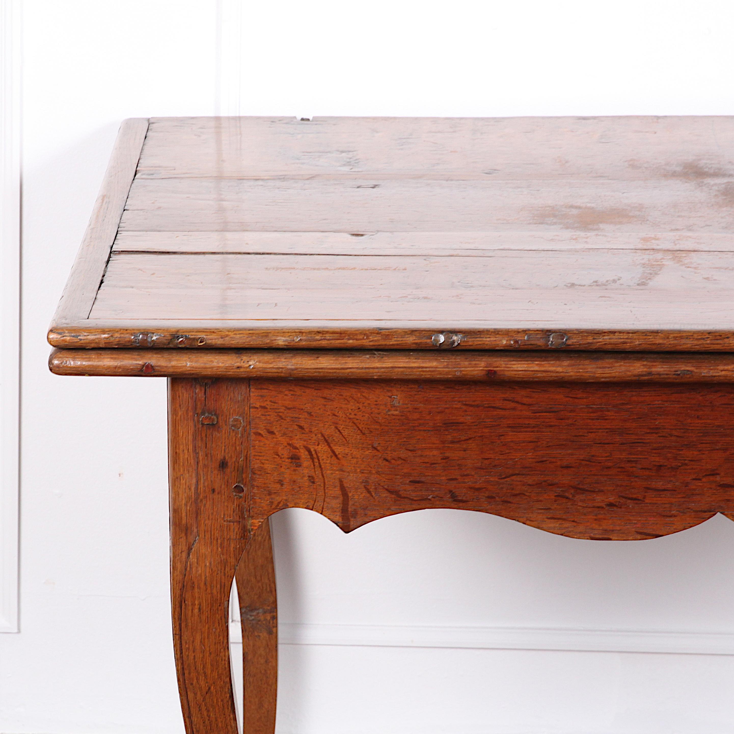 19th century French oak extending farm table with a fold-open top and extending base to support the top when opened. An unusual design and suited to small spaces where occasionally a larger table is desired. Shaped scalloped skirt and simple