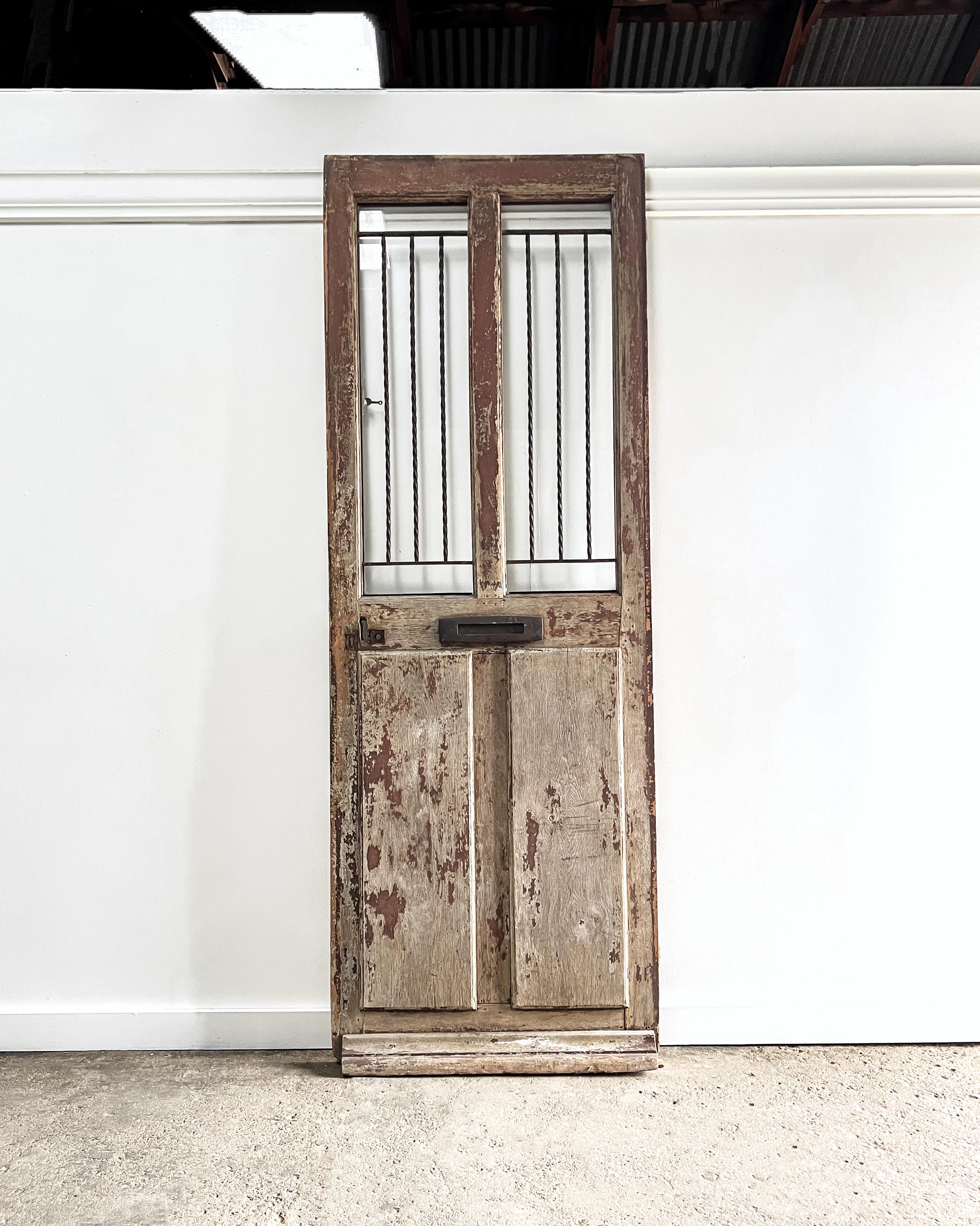 Reclaimed French 2 lite over 2-panel configuration exterior door with window grille and mail slot. Featuring a unique design with an inset grille and window that swings open, the door will add old-world charm and character to your modern