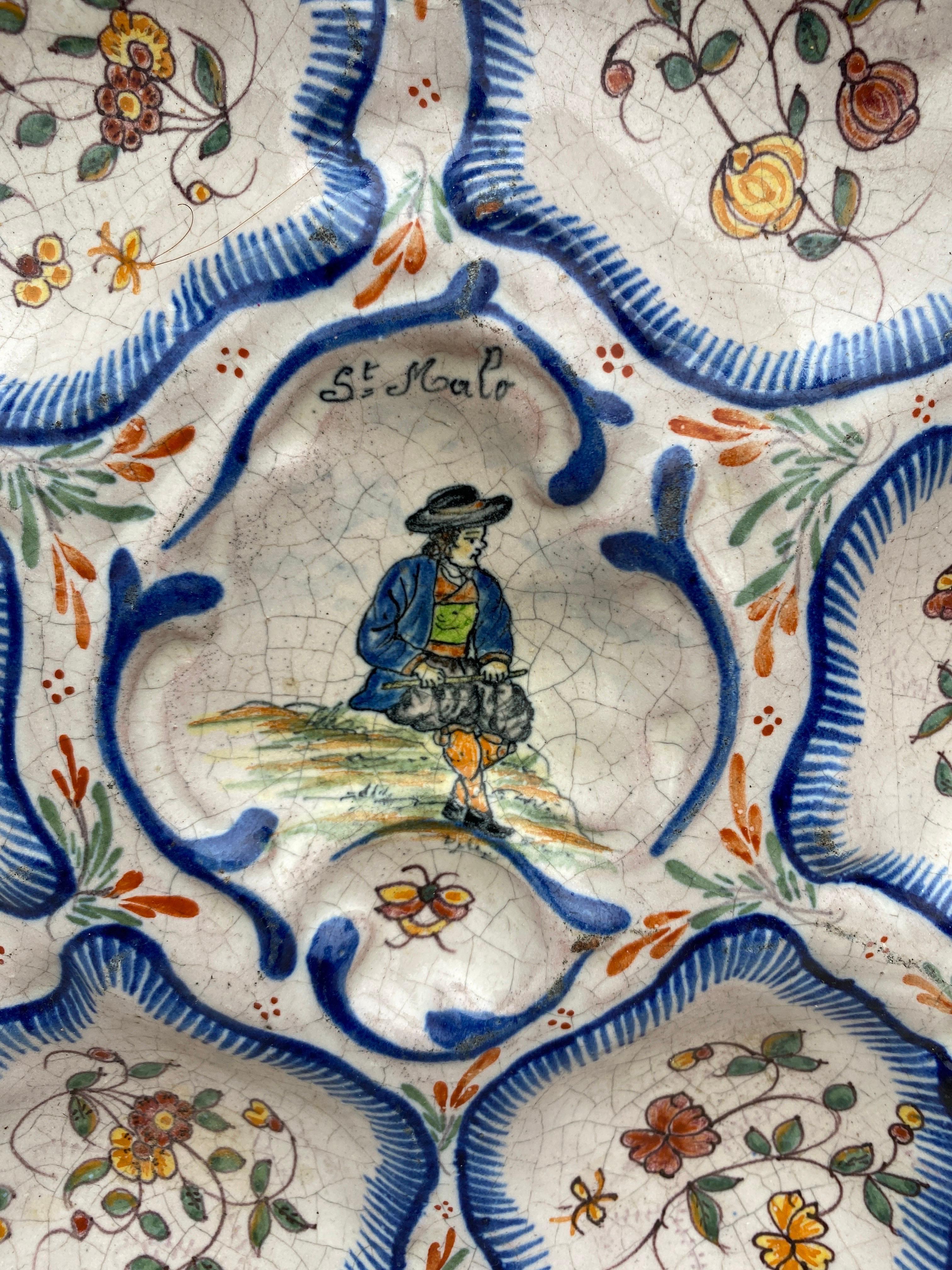 Antique rare large French faience oyster plate, circa 1890 made by the manufacture of Malicorne with a Breton man on the center and flowers and butterflies.