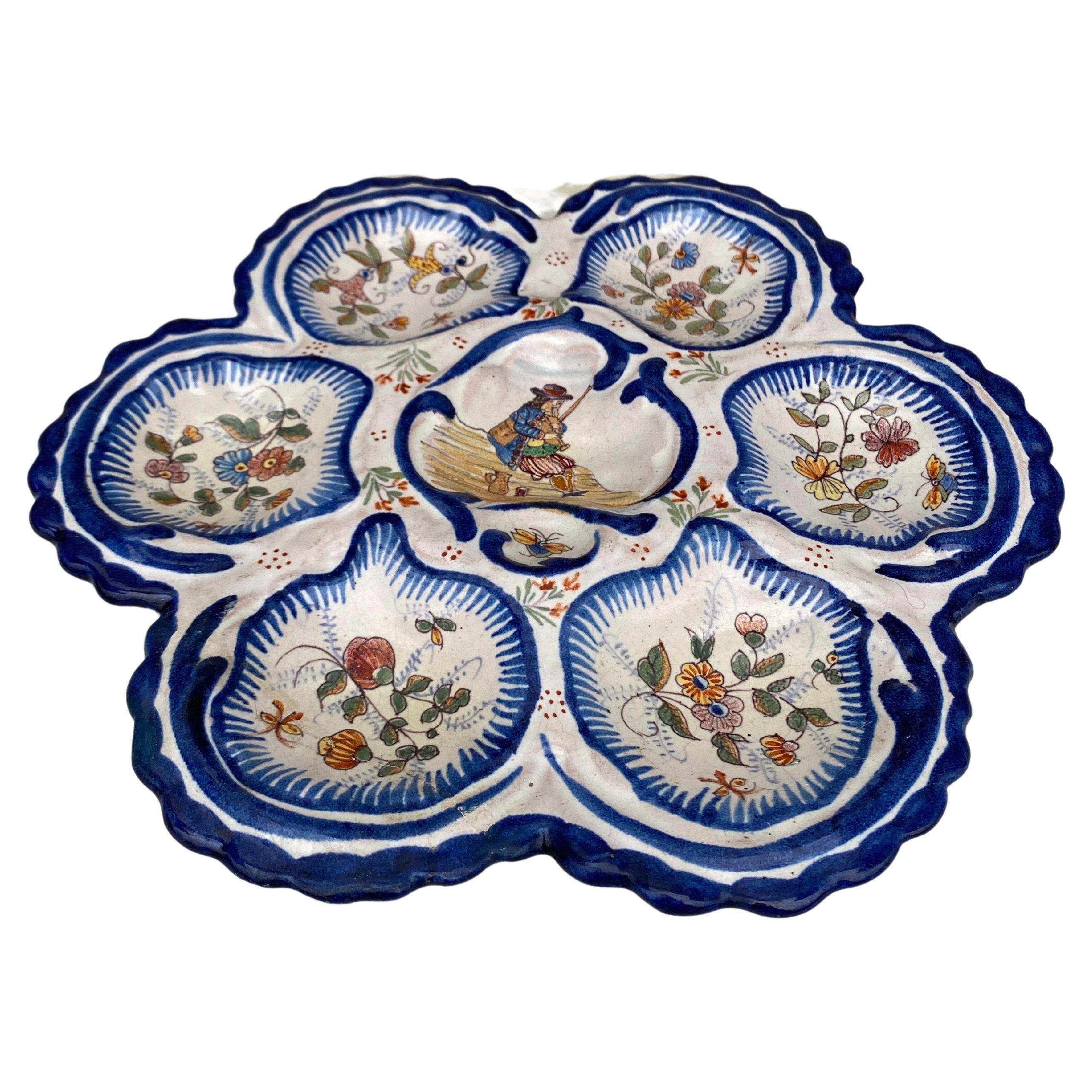 Antique rare large French faience oyster plate, circa 1890 made by the manufacture of Malicorne with a Breton man on the center and flowers and butterflies.