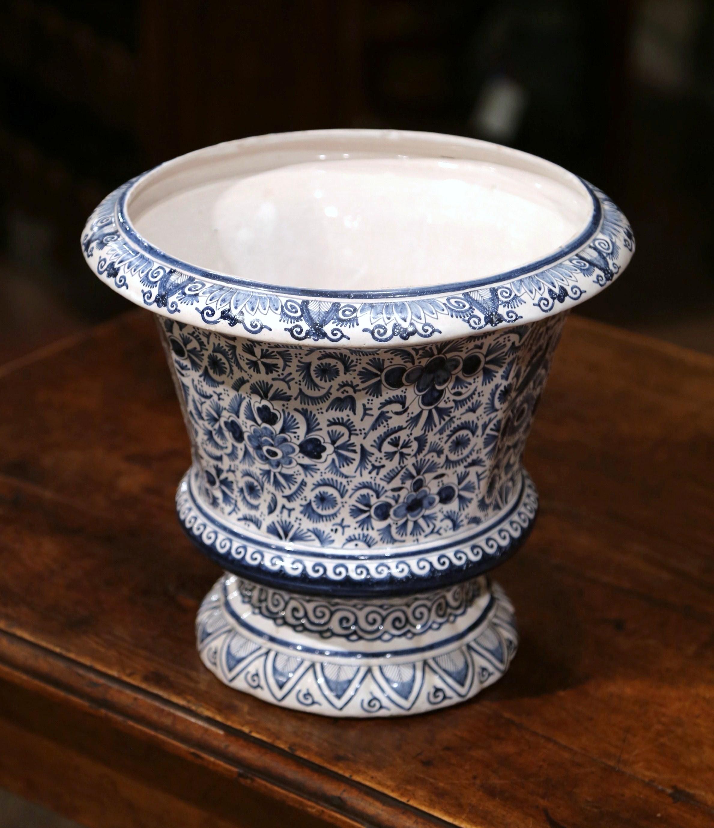 The traditional Classic antique ceramic planter was crafted in France, circa 1870; round in shape, the large faience vase has a wide mouth at the top, a beveled lip, and is hand painted with detailed floral and bird motifs in a blue and white