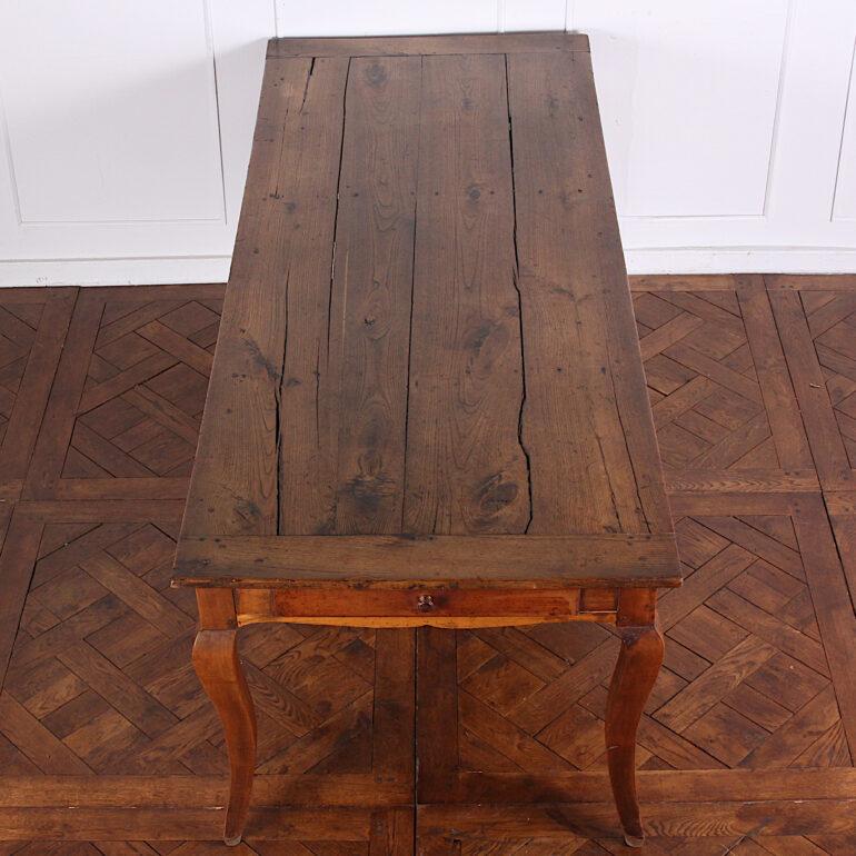 19th century French farm table in elm and oak with a planked top above scalloped apron, fitted with a drawer to one end and raised on serpentine legs. Slightly longer than many French farm tables we see- generous space for three down each side. 

 