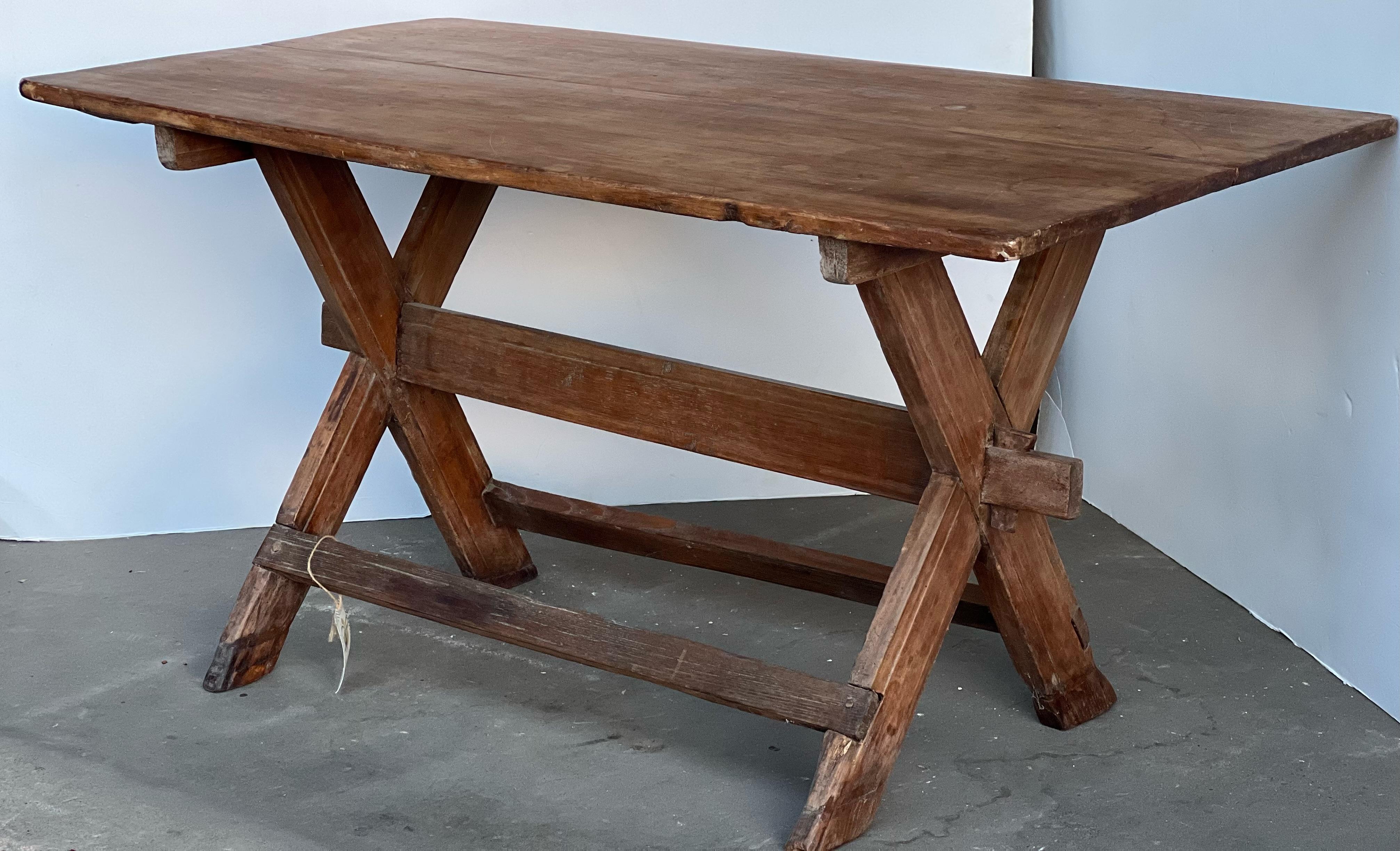 Here is a beautiful farm table that features a cross leg. Perfect for a console table, desk or small kitchen area. This unique piece can also be used as a kitchen island. Repairs have been made to this piece. It is on good condition and is sturdy.