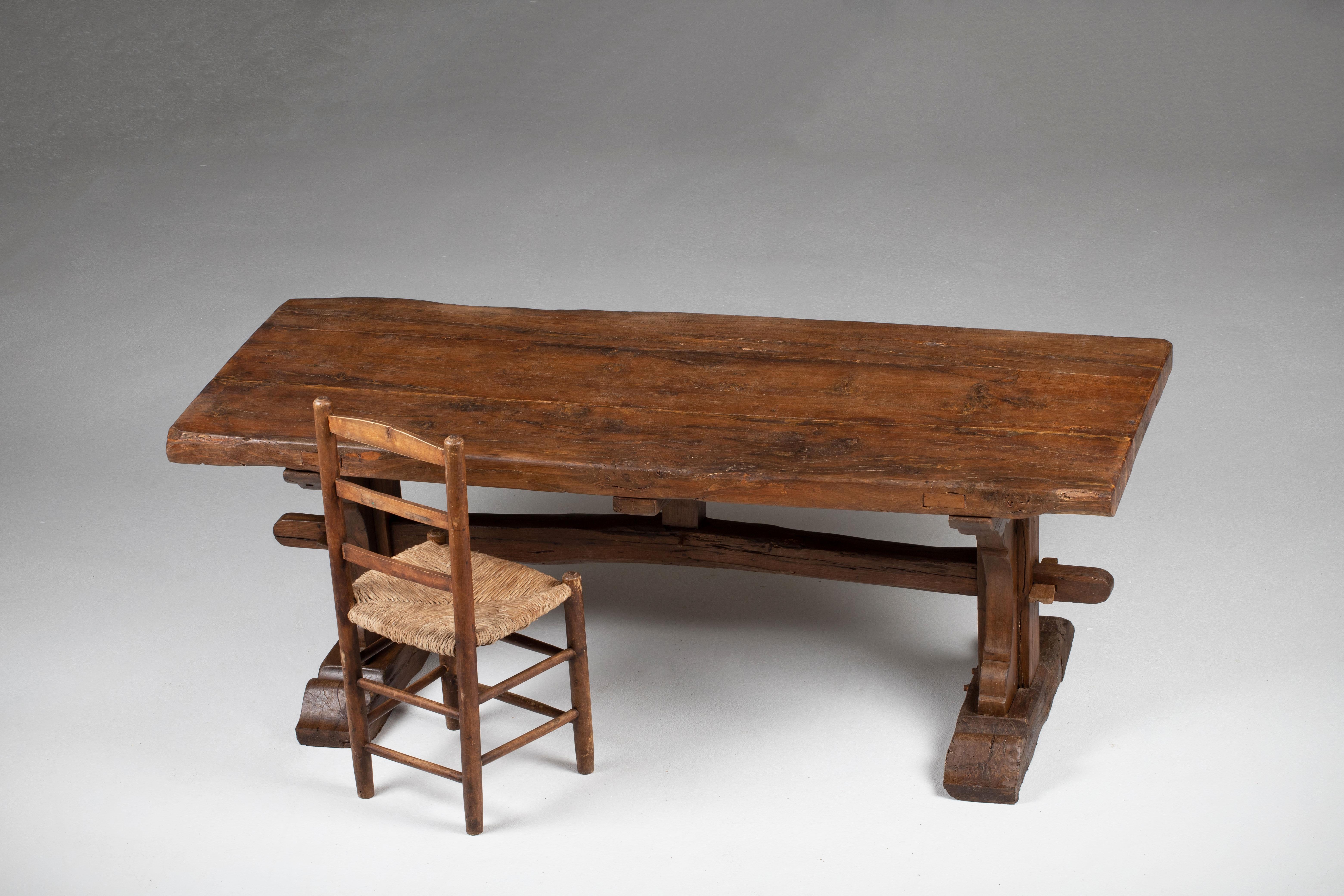 A composition of elemental strength and rural dignity, this 19th-century French trestle table reveals a language of honest construction and quiet monumentality. Hewn from solid oak timbers nearly 2.5 inches thick, the broad tabletop carries the