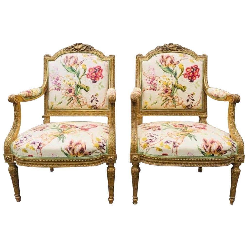 Ein schönes Paar französischer Fauteuil-Sessel aus vergoldetem Holz aus dem 19. Sie sind fein geschnitzt mit Theatermasken, Flöten und anderen Musikinstrumenten. Wunderschöne florale Polsterung mit hellgrüner und cremefarbener Einfassung. Die