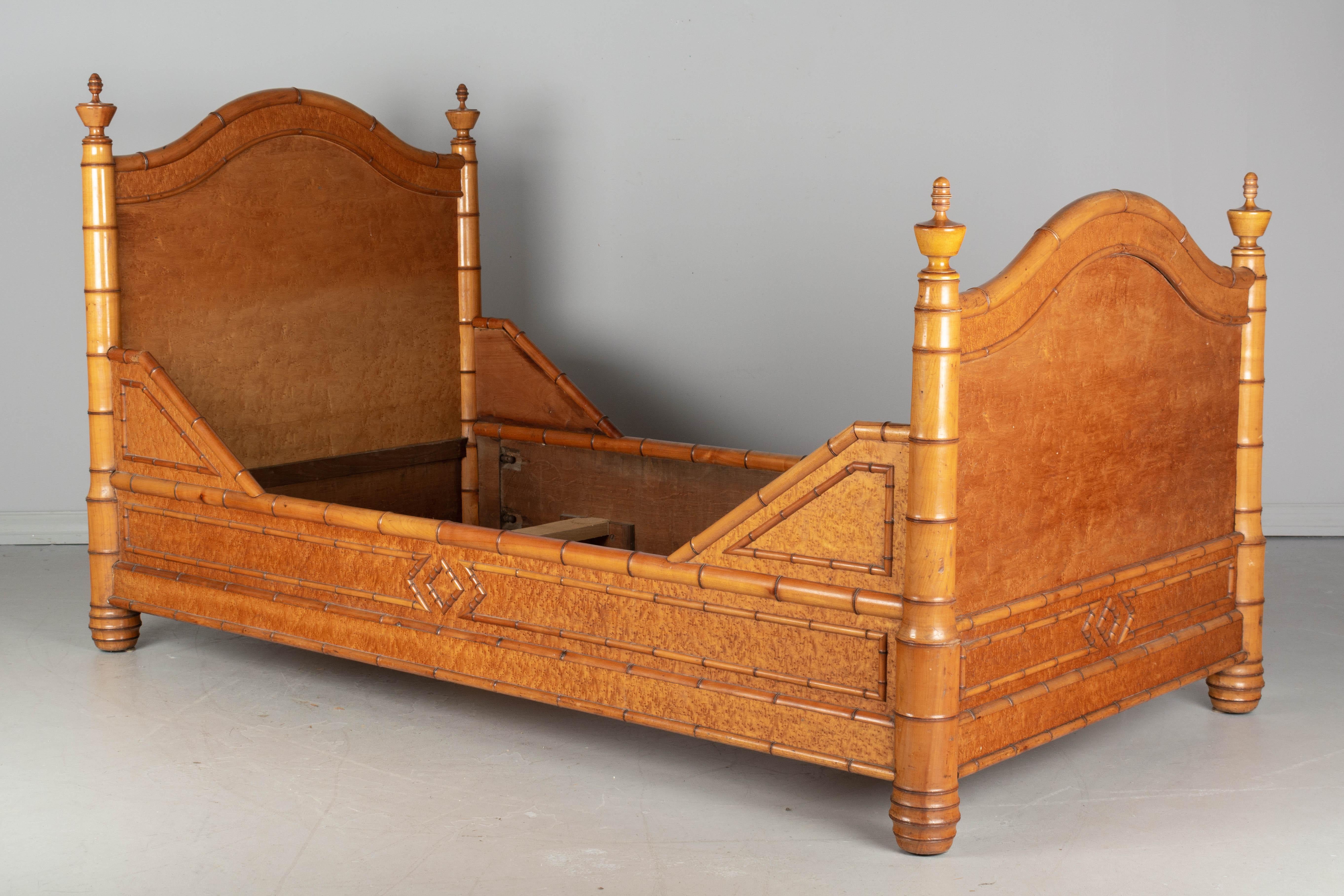 A good quality 19th century French faux bamboo bed, handcrafted of pitch pine with carved cherrywood decorative trim. Nice diamond pattern details. Two of the turned final bedposts are replaced. Good sturdy construction. In four parts and easy to