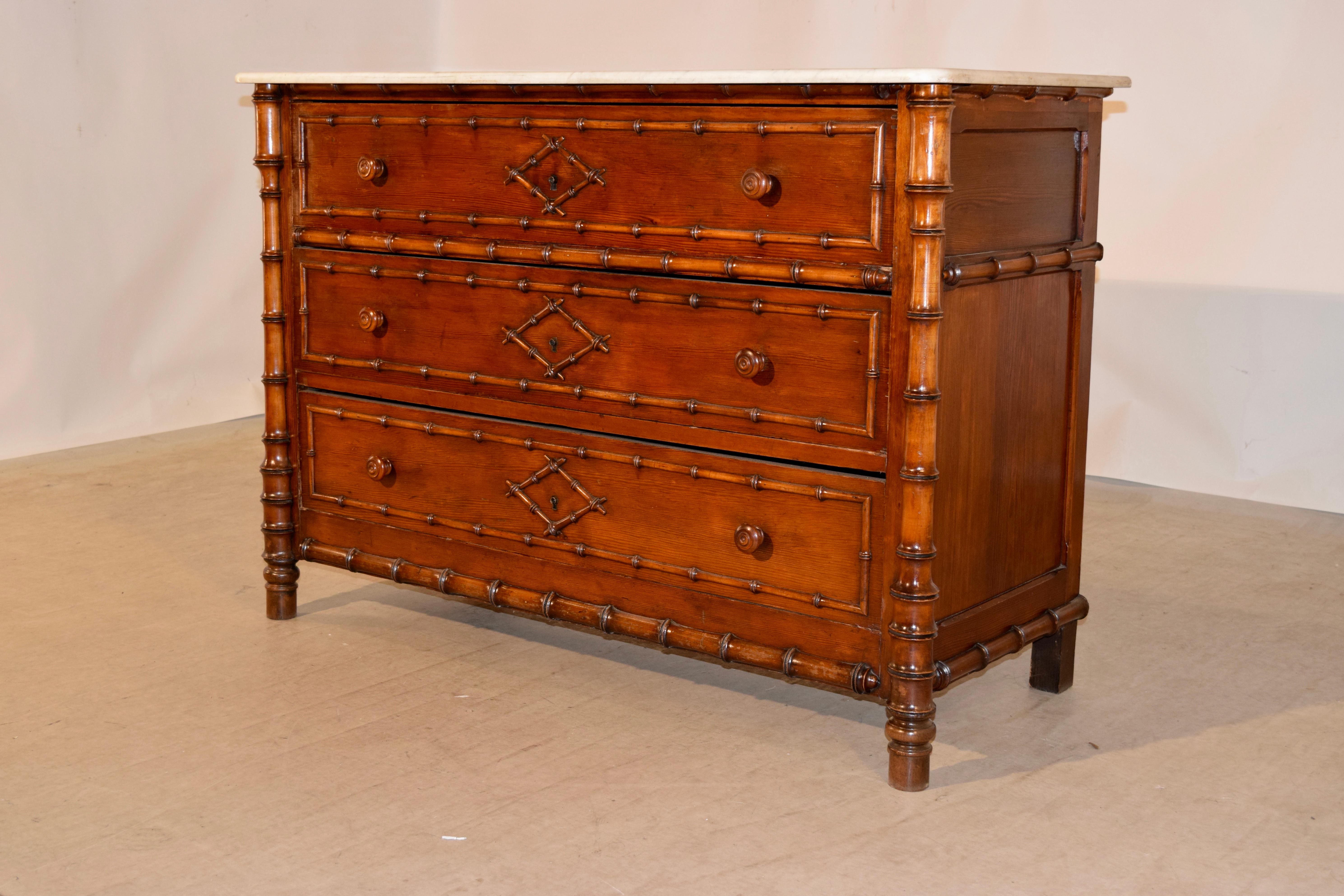 19th century French faux bamboo chest of drawers made from cherry. The top is made of the original marble and retains some staining from age and use. The case is wonderfully detailed with hand panelled sides, banded with faux bamboo molding and