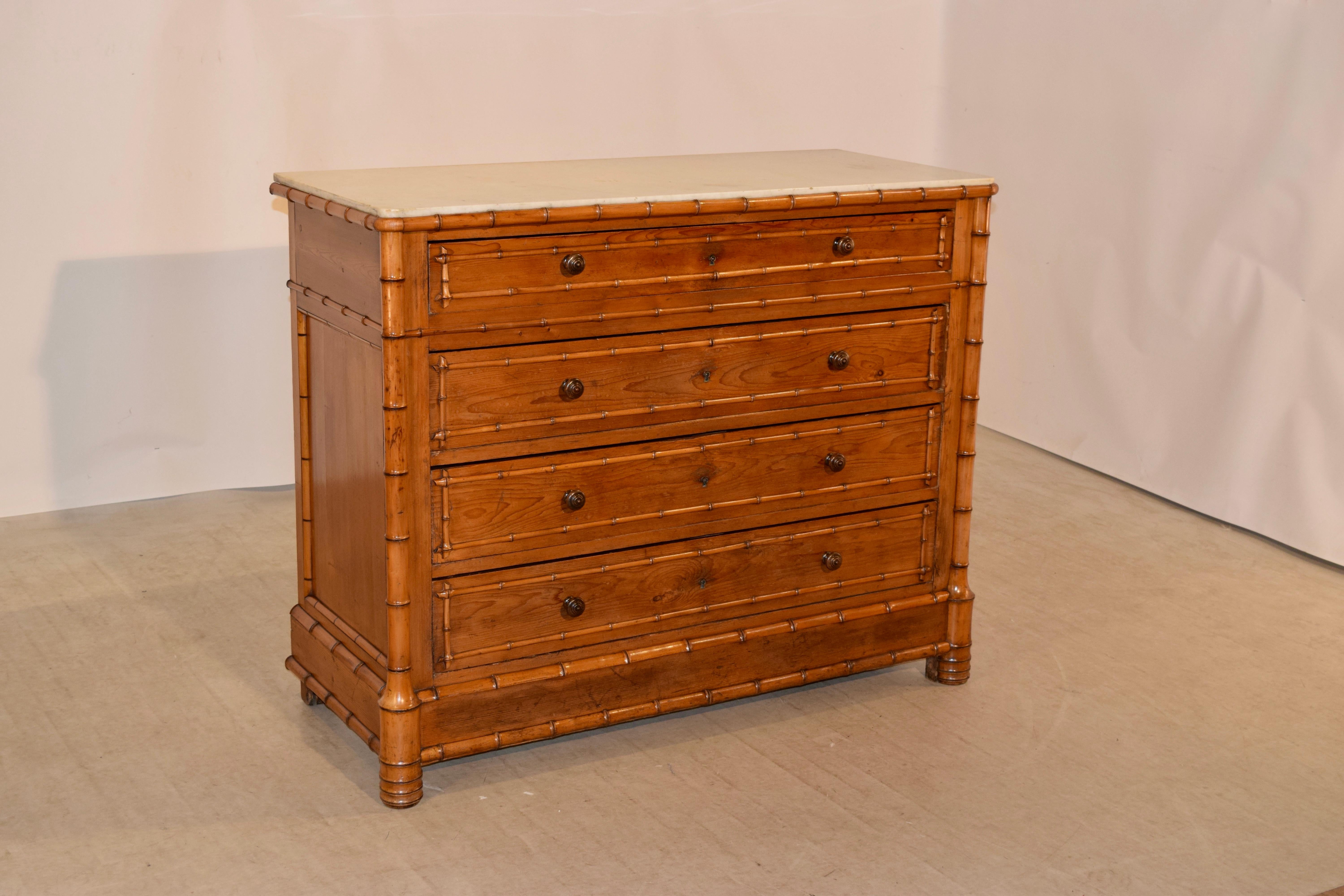 19th century French faux bamboo chest of drawers made from cherry. The top retains the original marble, banded by faux bamboo molded decoration, following down to hand paneled sides and four drawers in the front of the case, all with hand-turned