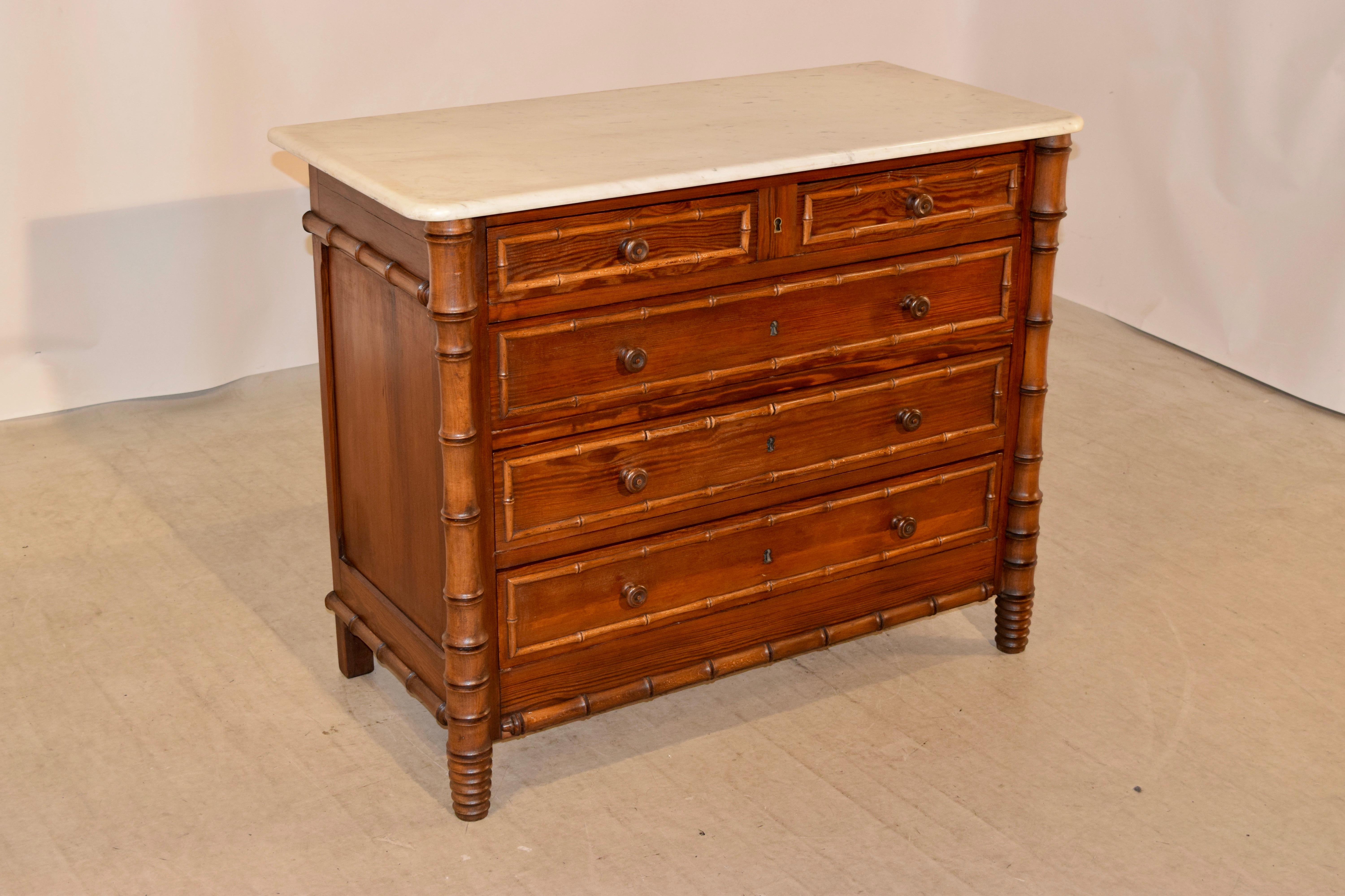 19th century faux bamboo chest of drawers from France with the original marble top, which has normal staining from age and use. The case has two drawers over three drawers, all banded with faux bamboo molding and flanked by faux bamboo hand turned