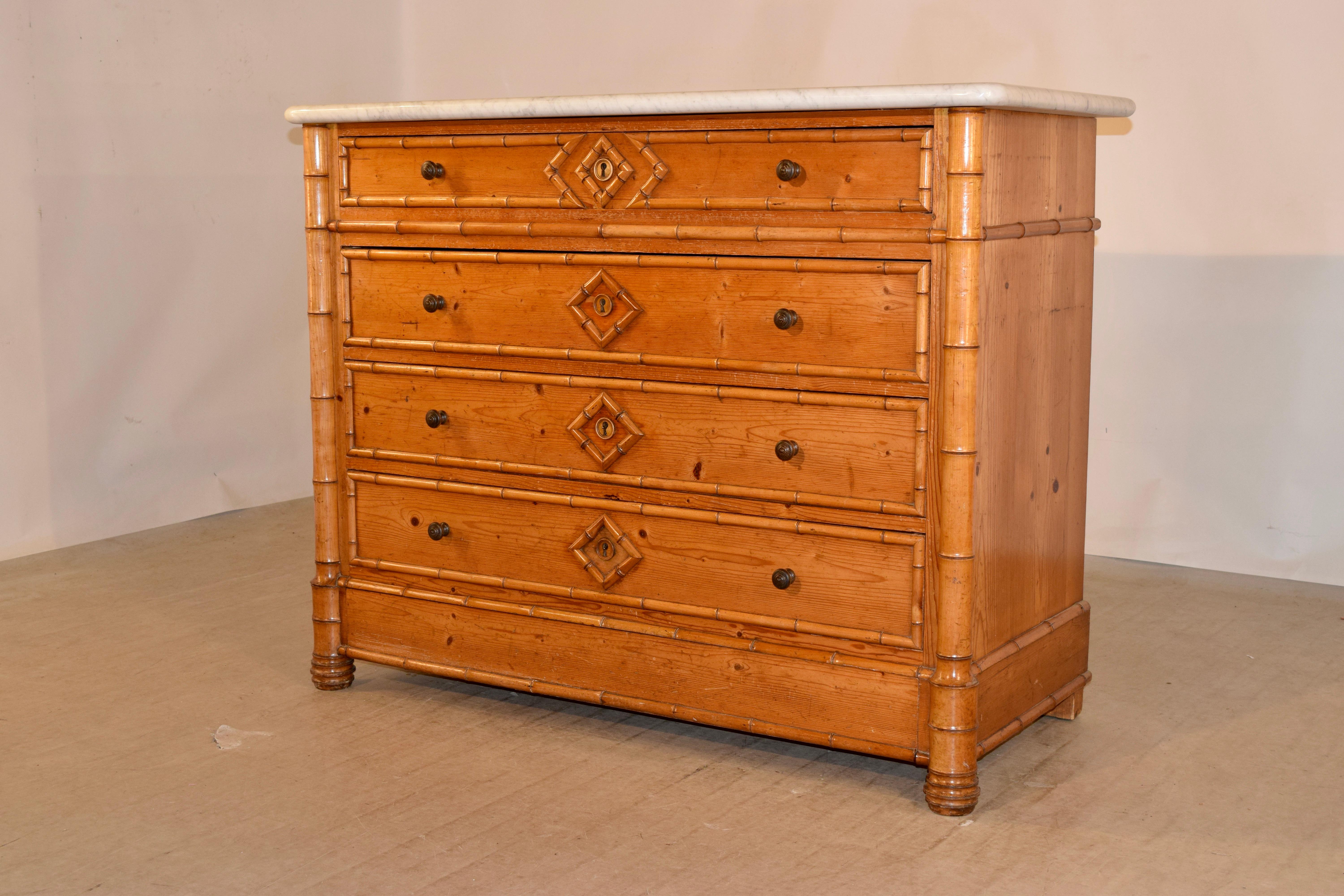 19th century faux bamboo chest of drawers made from cherry and pine. The top is Carrara marble, and follows down to simple sides with hand turned faux bamboo moldings and four drawers in the front, also with faux bamboo moldings. The drawers are