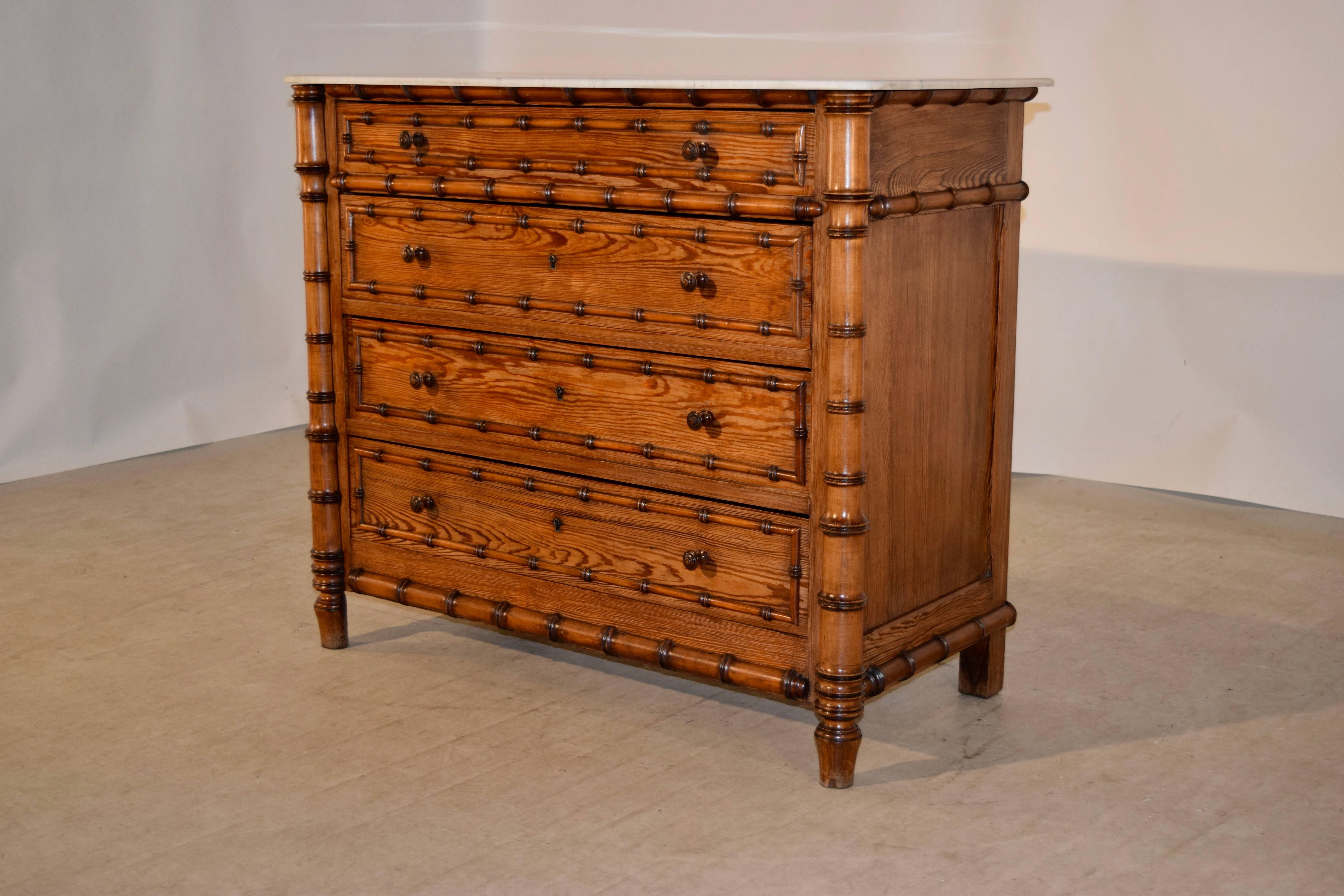 19th century French chest of drawers with a marble top which follows down to four drawers, all banded with faux bamboo turned moldings, flanked by faux bamboo turned columns. The sides are paneled as well. Gorgeously grained pitch pine.
