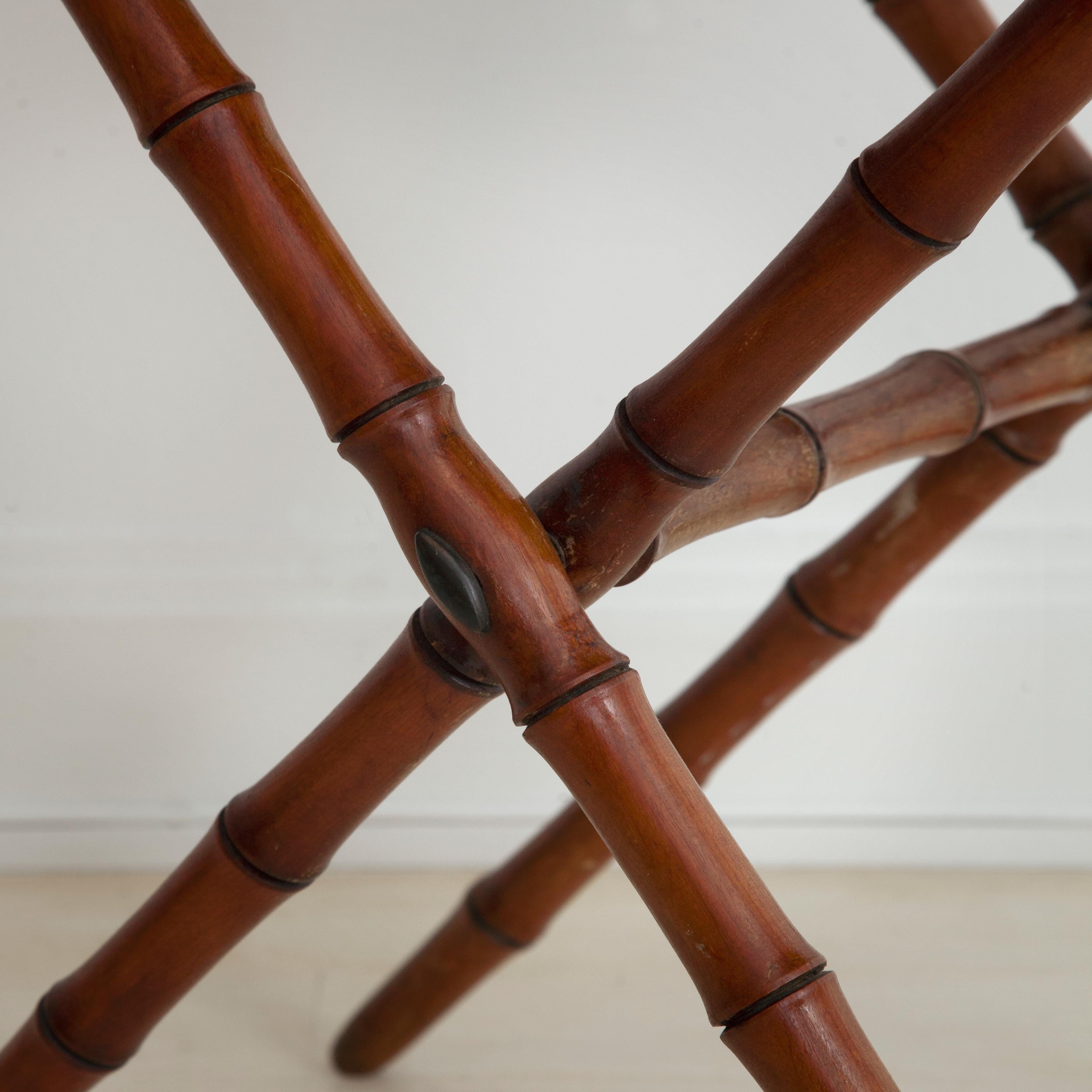 19th century French faux bamboo folding table. Carved wooden legs imitate bamboo shafts beneath a plain surface tabletop.