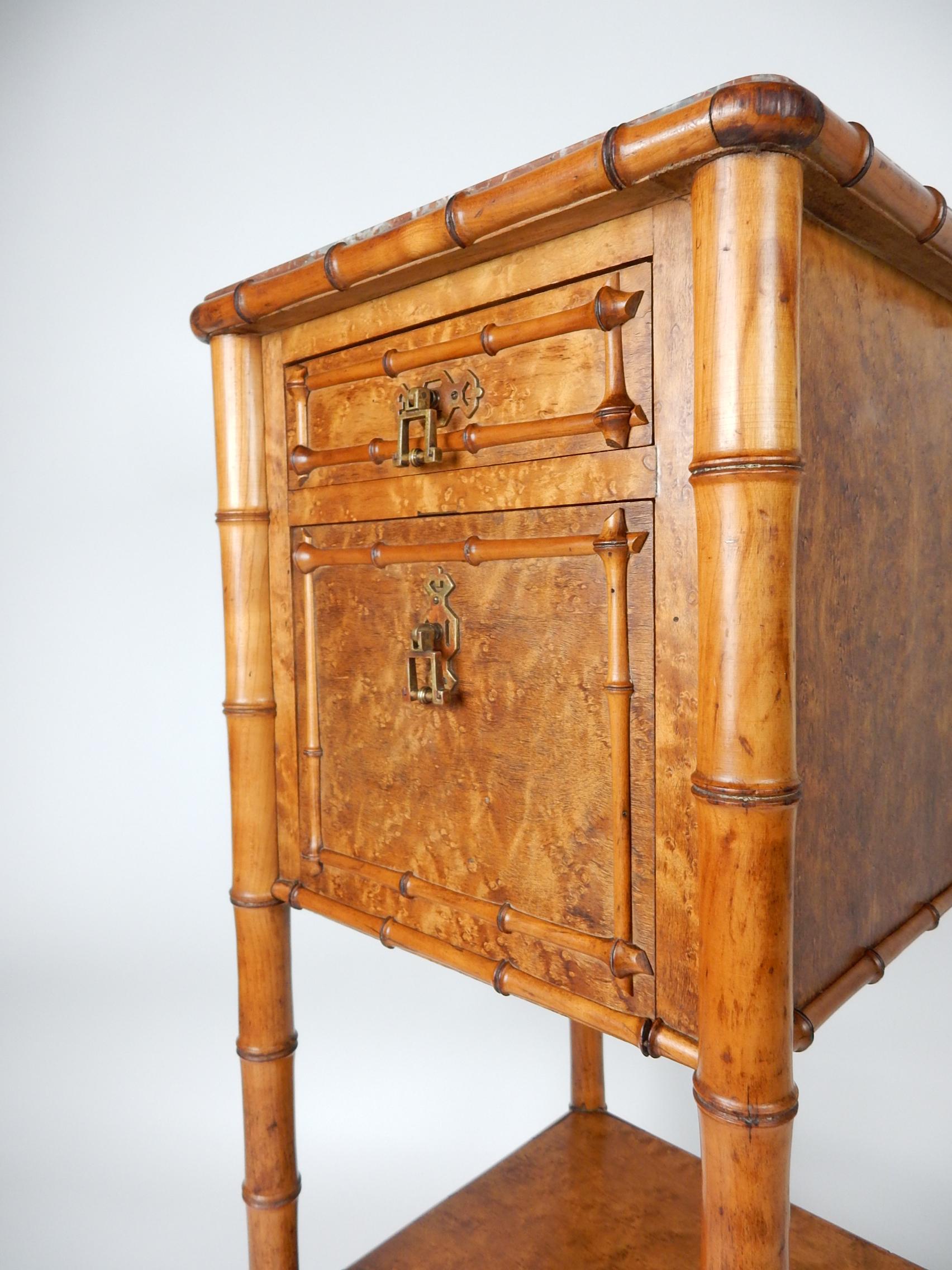 Exceptionally crafted wash stand/table from France, mid-19th century, Aesthetic Movement era.
Inset red marble top, a single drawer and a white marble lined cabinet.
Faux bamboo stem legs with a realistic, hand carved bamboo 