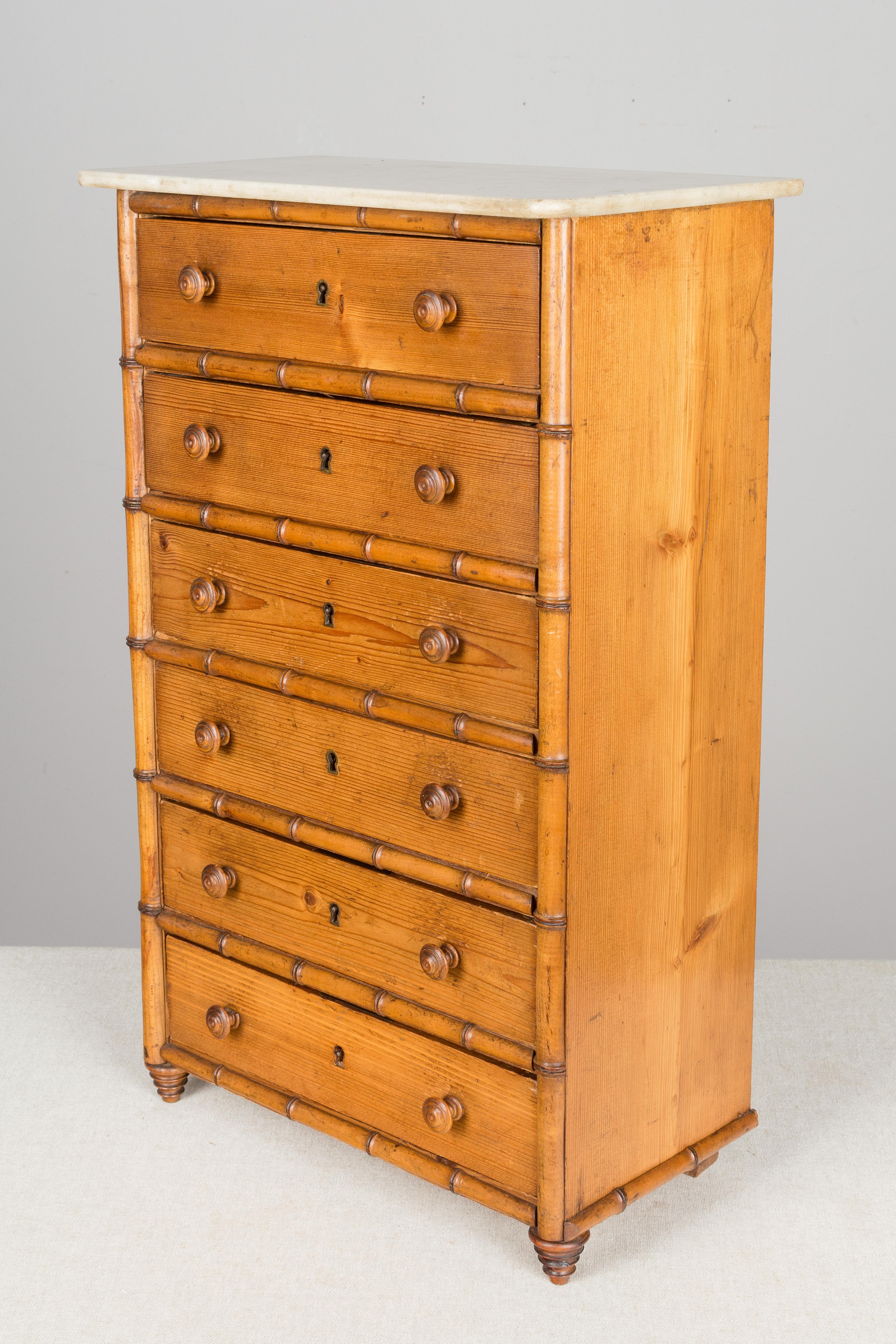 A 19th century French faux bamboo miniature chest of drawers, or chiffonier, made of solid cherry and pine with white marble top. Six drawers with turned wood knobs and locks, but no key. Some of the locks are missing. All original. Perfect for